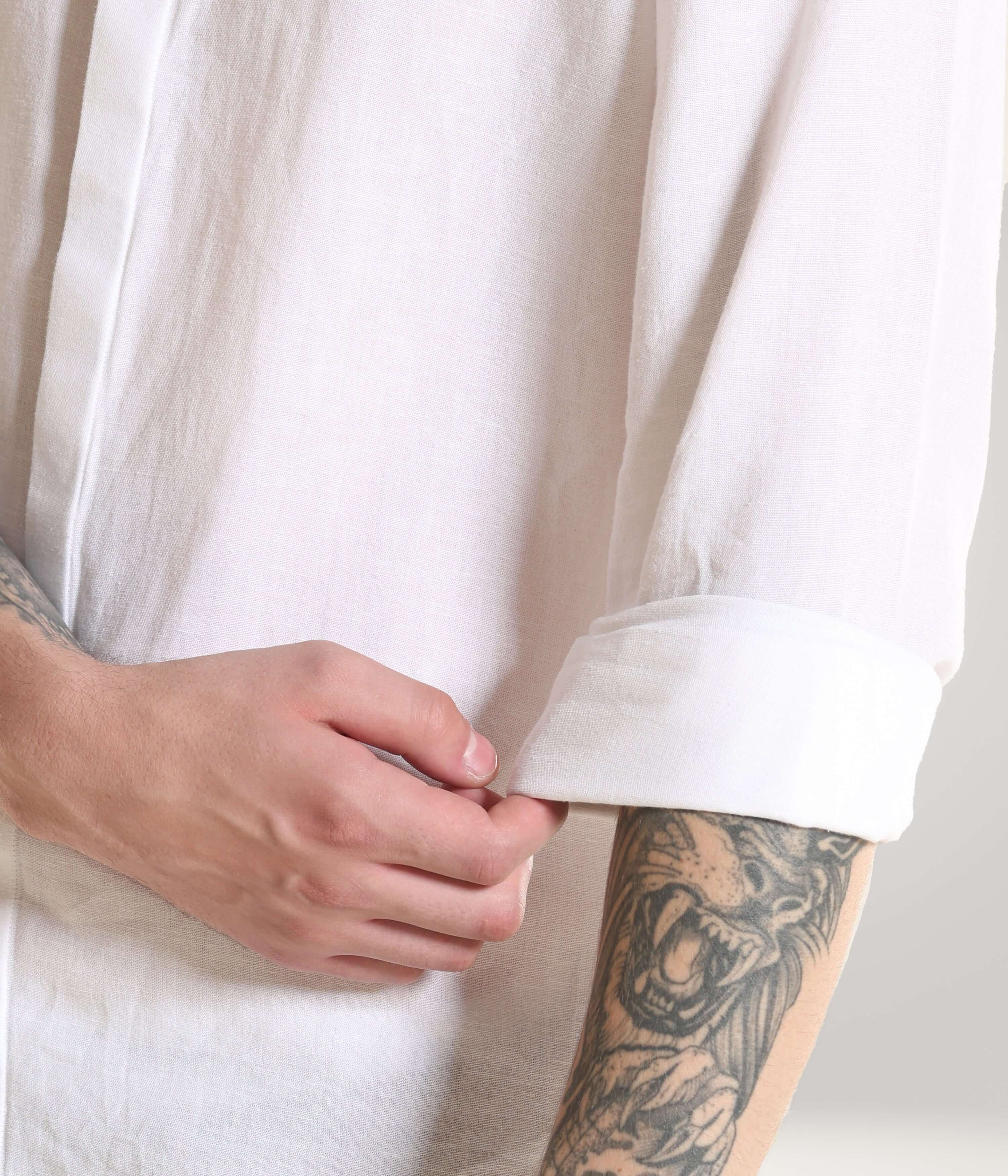 Man rolling up sleeve of White Wolf Turms Intelligent Linen shirt showing durability and premium craftsmanship.