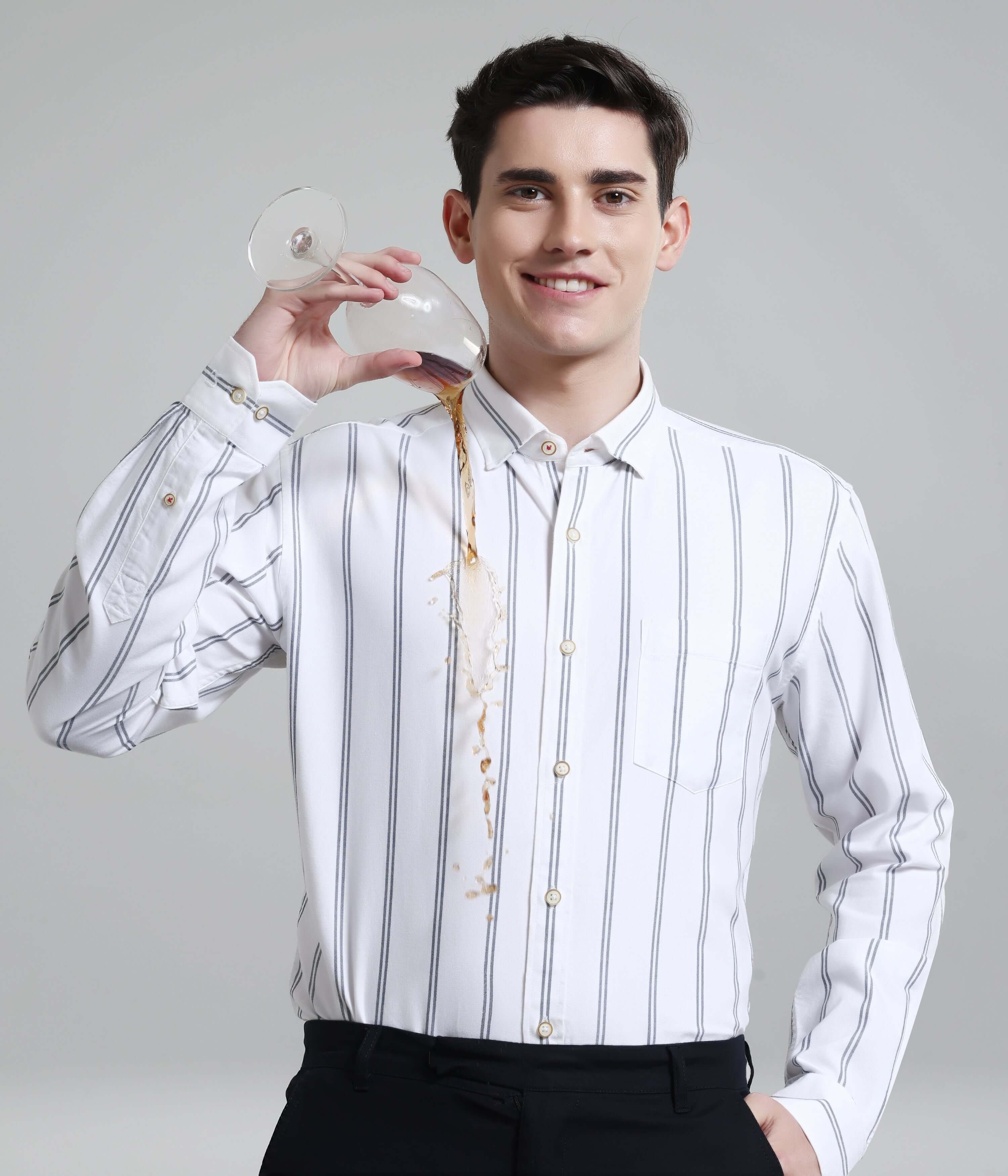 Man wearing Colada White stripe shirt, demonstrating anti-stain feature with spilled drink, high-quality premium menswear.