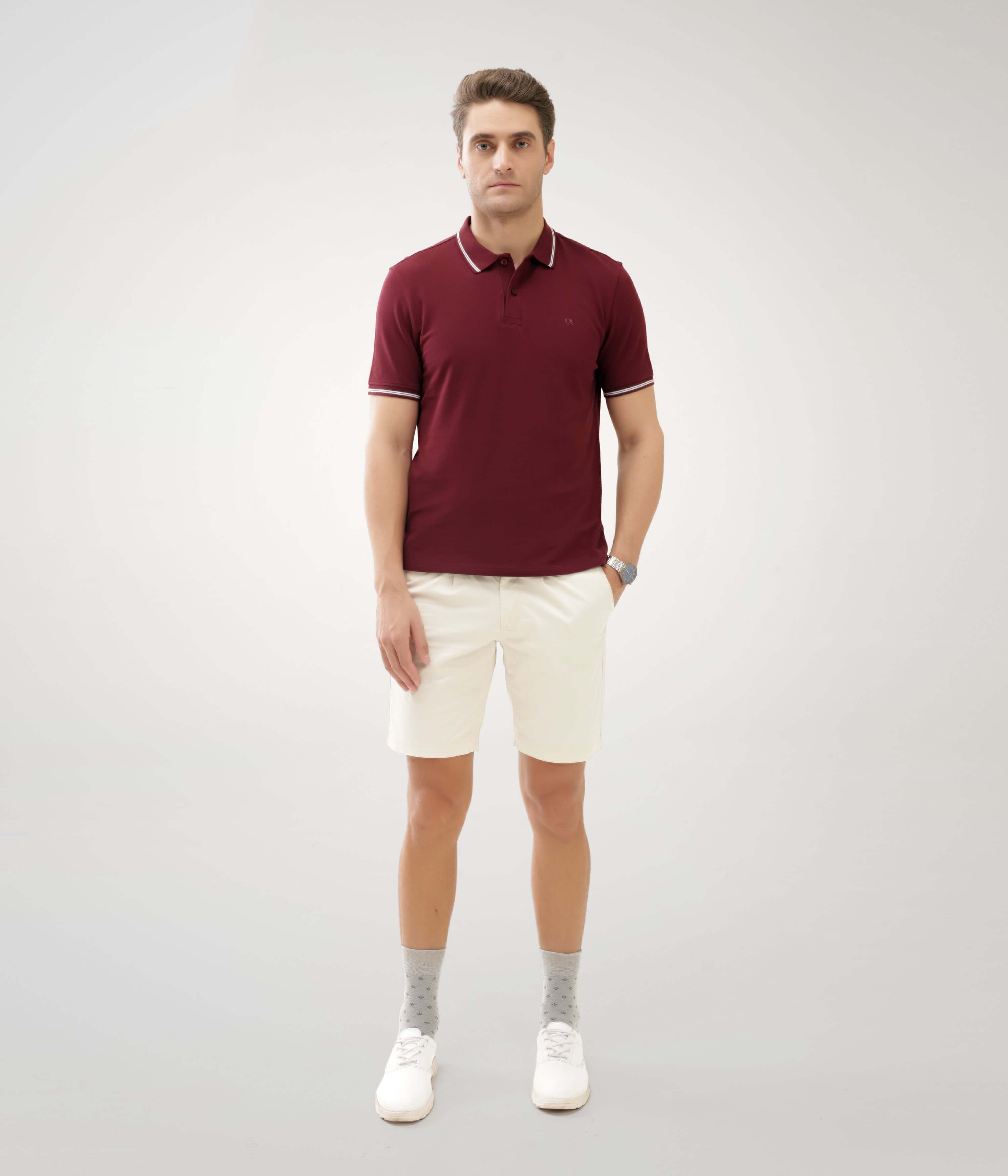 Man wearing maroon Turms Polo T-shirt tailored fit premium cotton anti-stain anti-odor intelligent apparel with white shorts.