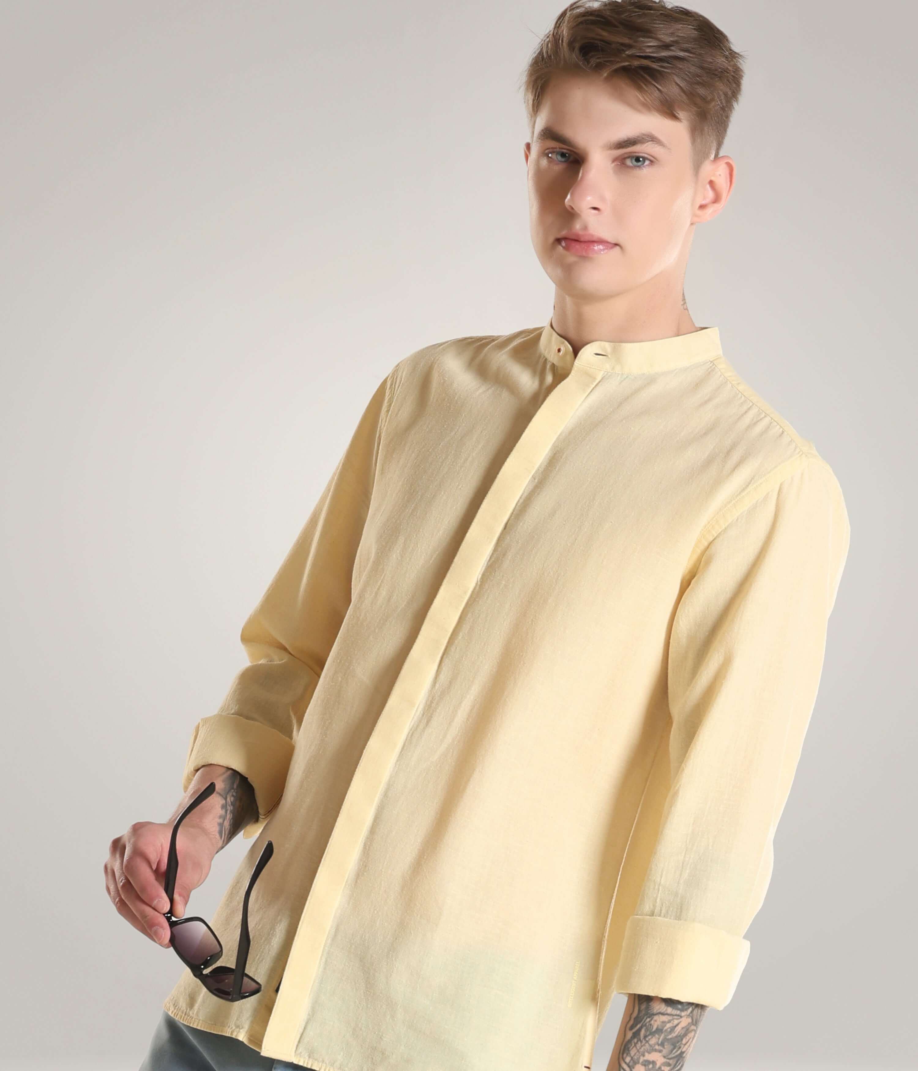 Man wearing pastel yellow Cotton/Linen Turms shirt with premium mandarin collar, showcasing Turms intelligent apparel's cooltech, antistain, and anti-odour features.