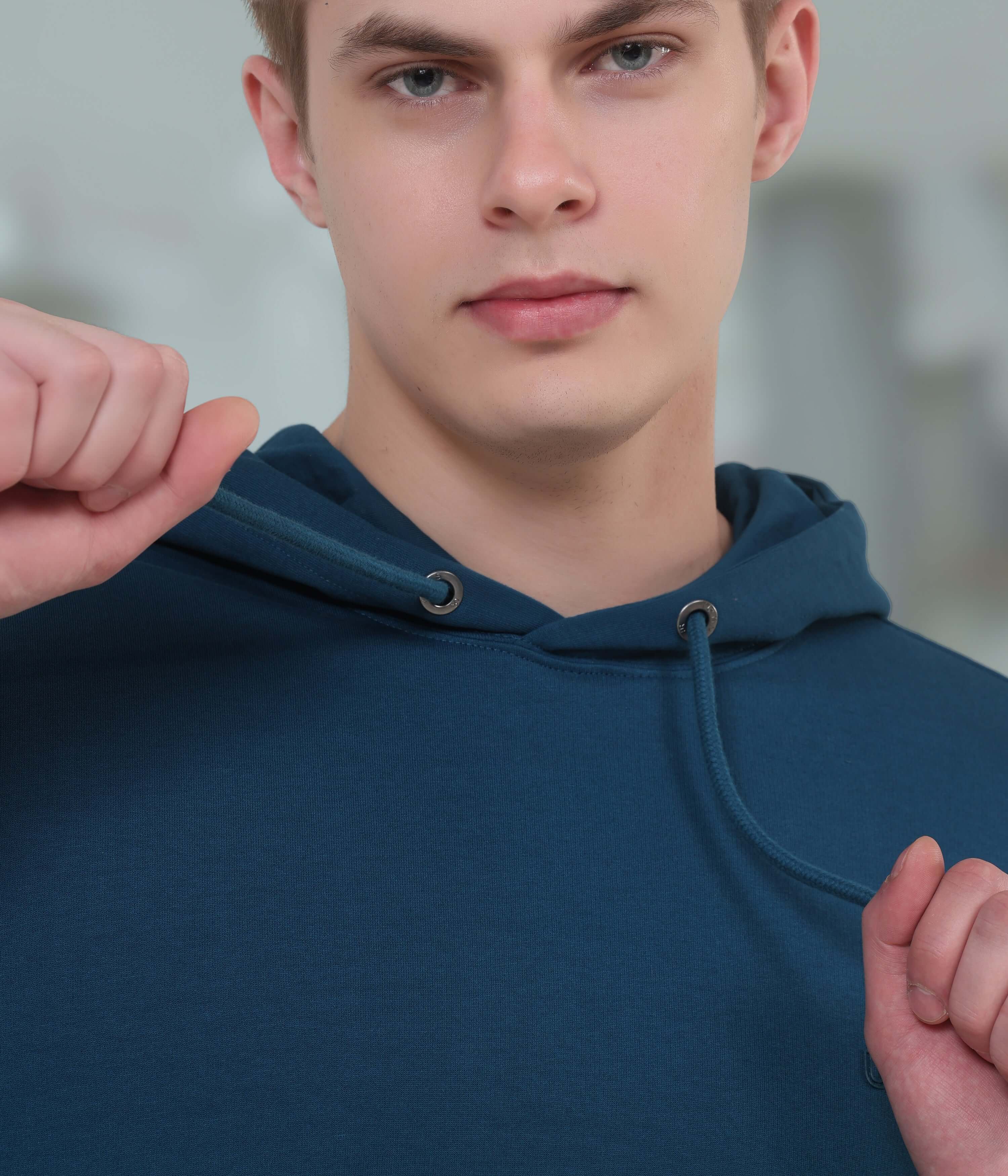 Young man wearing a blue hoodie, showcasing a stylish and comfortable design, perfect for everyday wear.