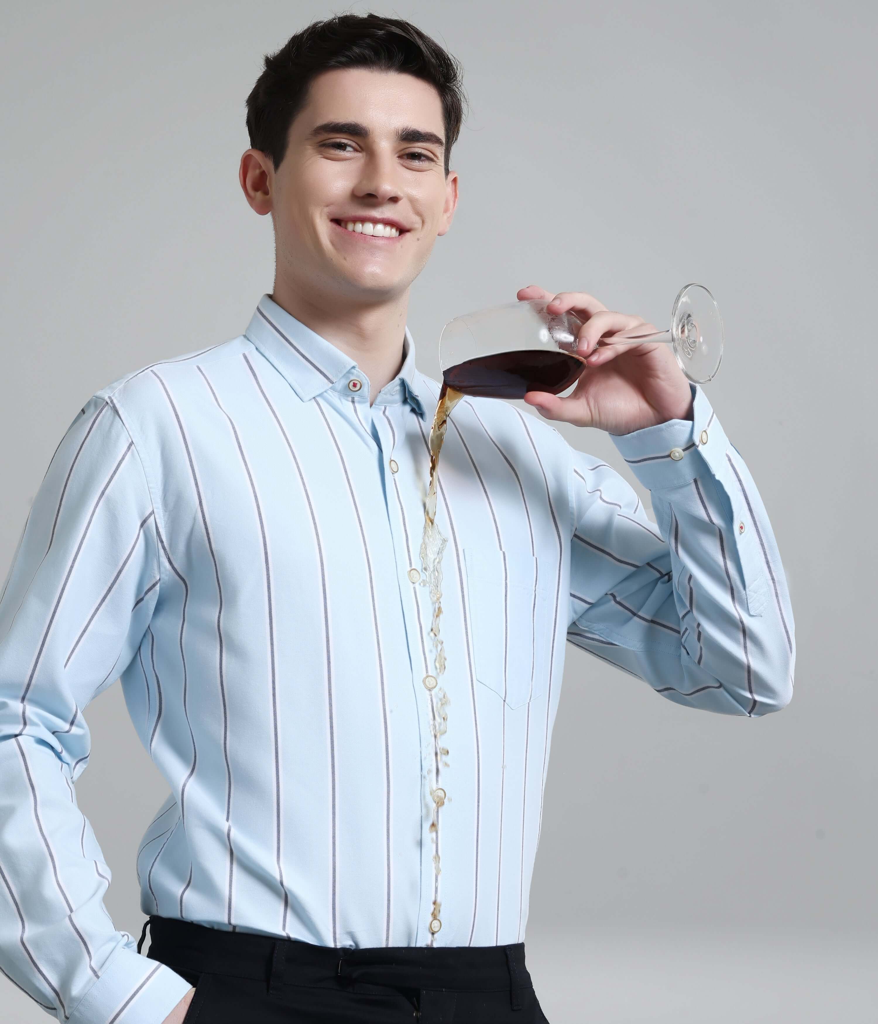 Man wearing anti-stain stripe shirt pouring wine, showcasing premium Oxford Turms menswear features like durability and style.