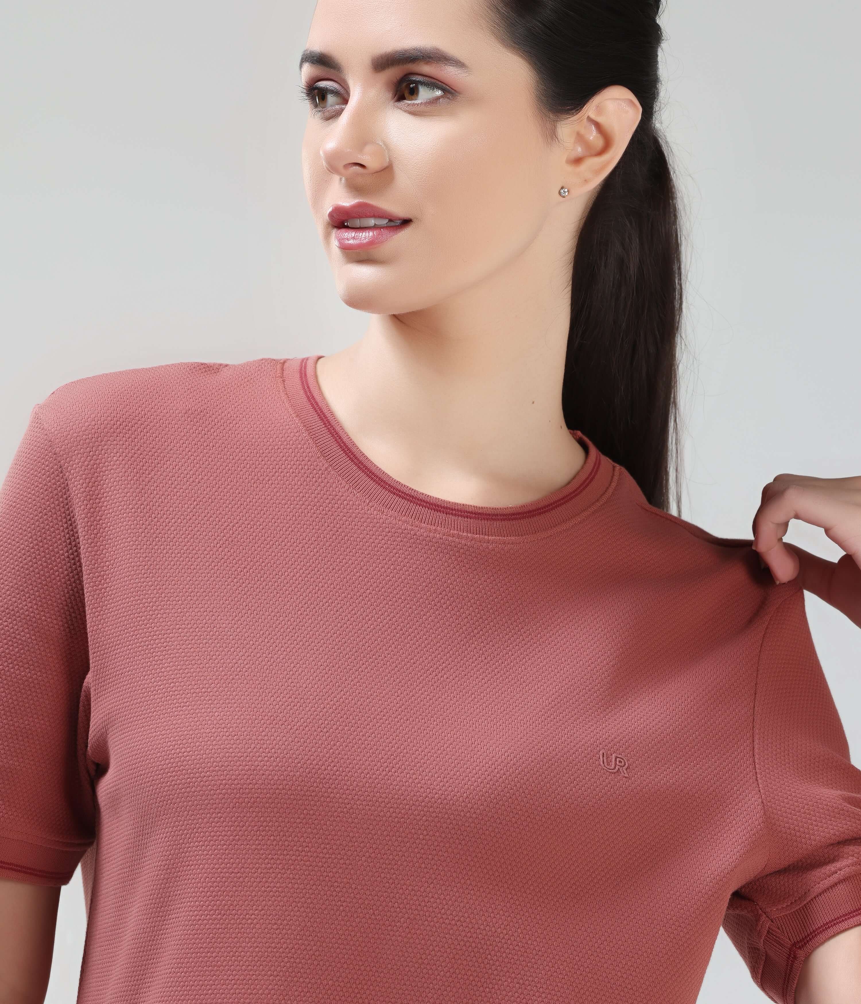 Woman wearing Turms Vivid Brick CoolTech T-shirt with honeycomb fabric, anti-odour, crew-neck, tailored fit, and made from premium cotton and spandex.