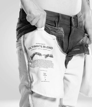 Man showcasing inner label of Black Sparrow high-performance denim pants with ultimate blend technology.