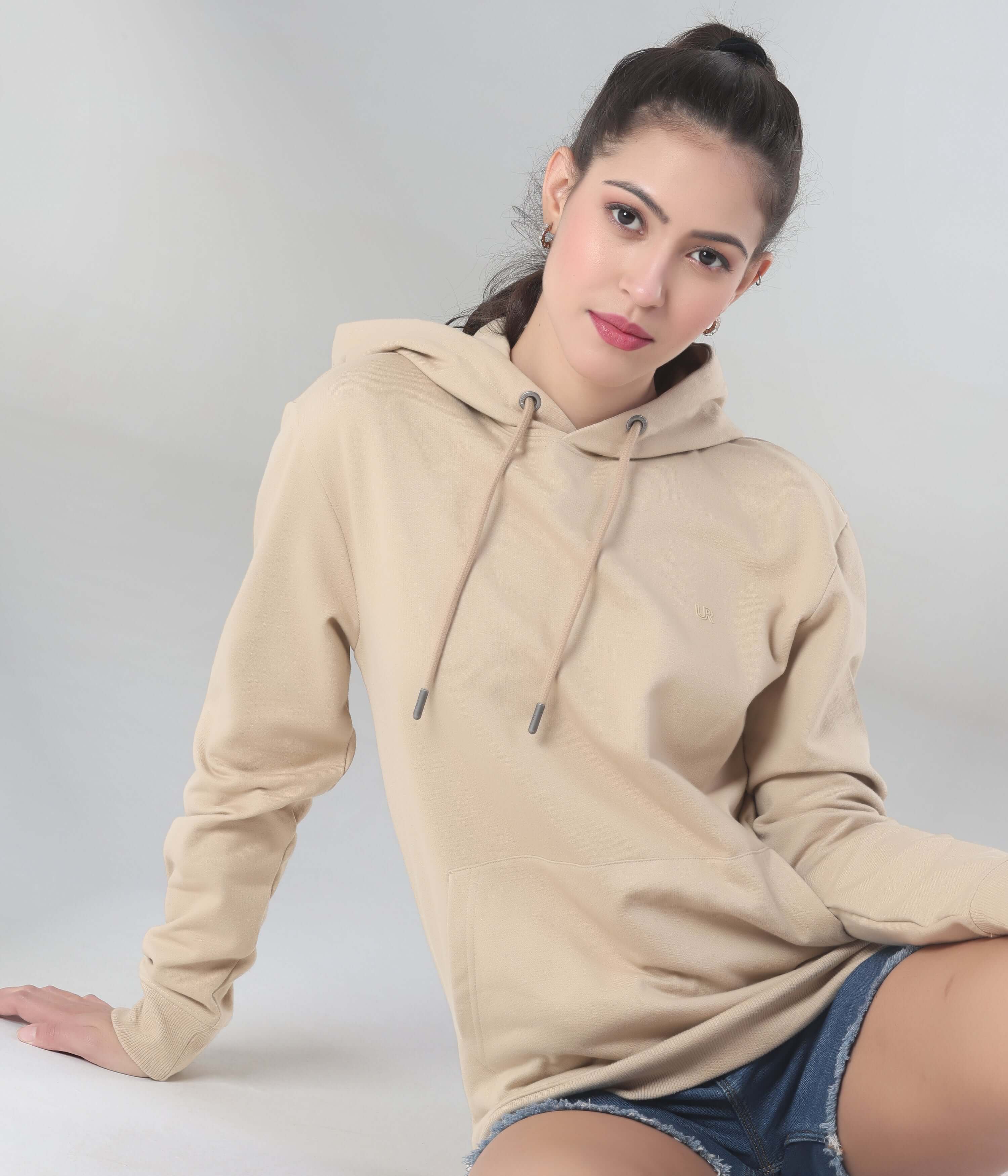 Model wearing a beige Turms Intelligent Hooded Sweatshirt, showcasing style and comfort, perfect for travel and everyday wear.