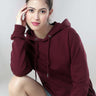 Stylish woman in a burgundy hooded sweatshirt, showcasing the best women's hoodie with a sporty vibe and comfort.