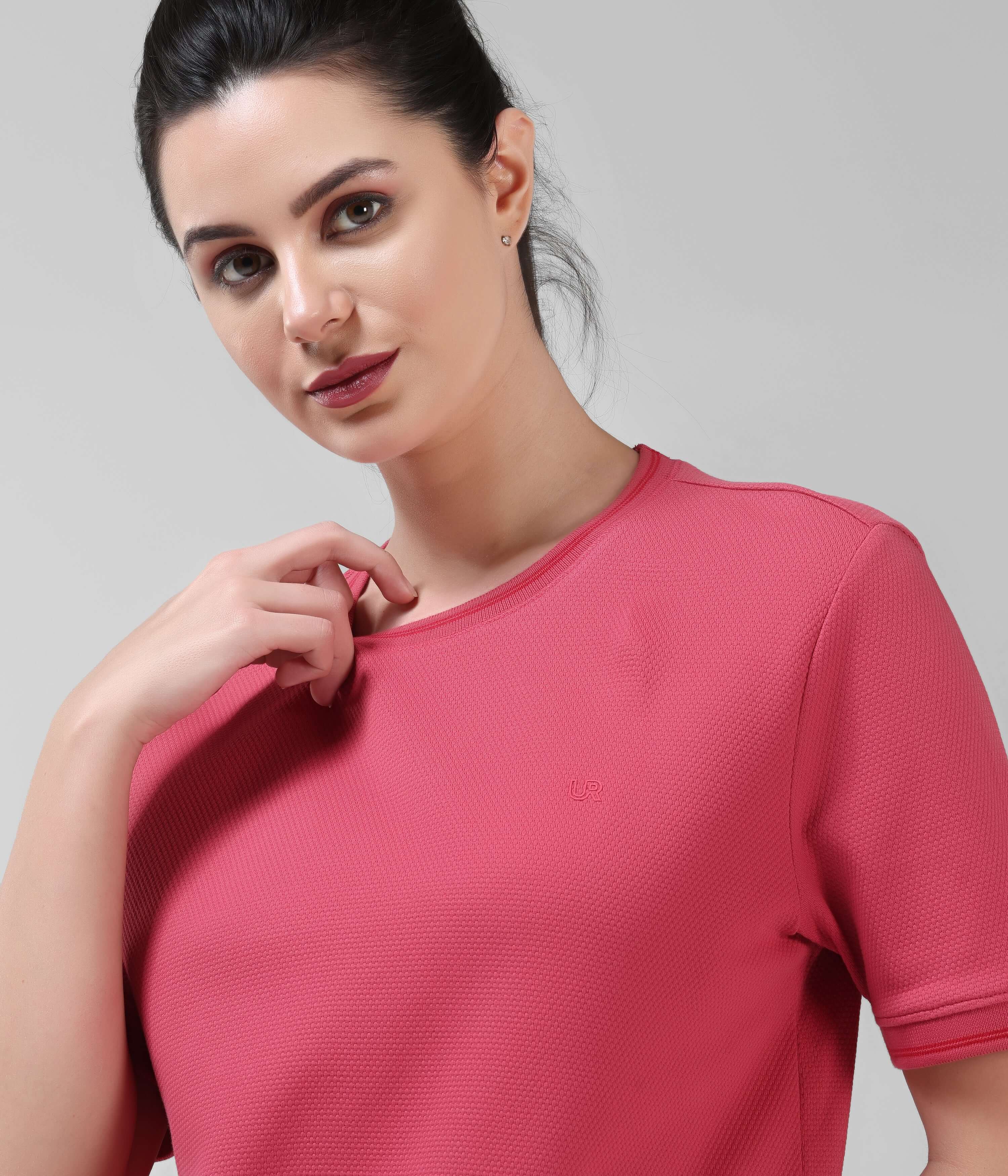 Woman wearing a Regal Pink COOLTECH T-shirt by TURMS Intelligent Apparel, featuring anti-odour honeycomb fabric and tailored fit.