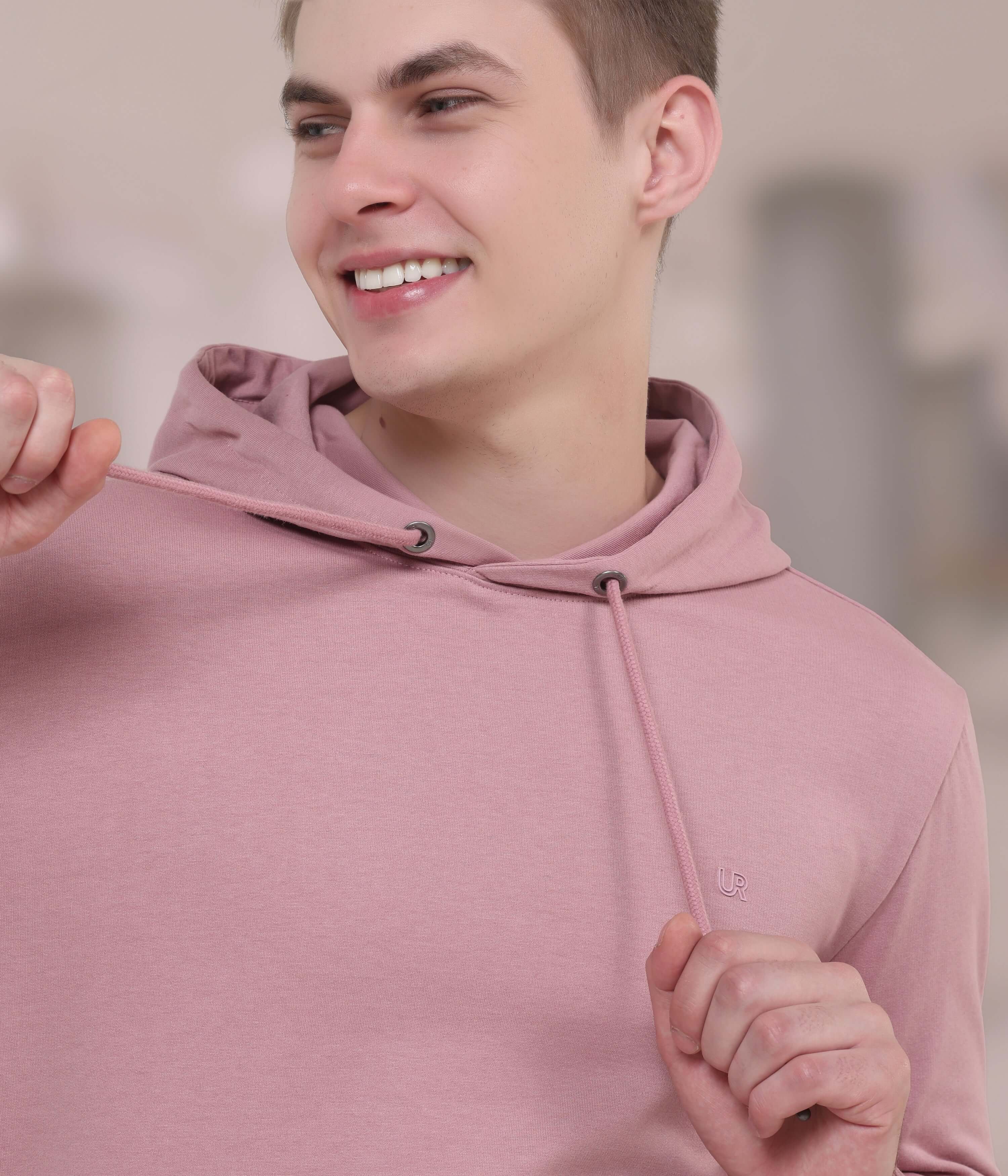 Model wearing a pink hooded sweatshirt, highlighting its stylish design and comfortable fit for everyday wear.