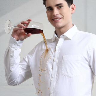 Man in white shirt demonstrating anti-stain feature with spilled drink, showcasing Toscana Lux Oxford Turms shirt's durability.
