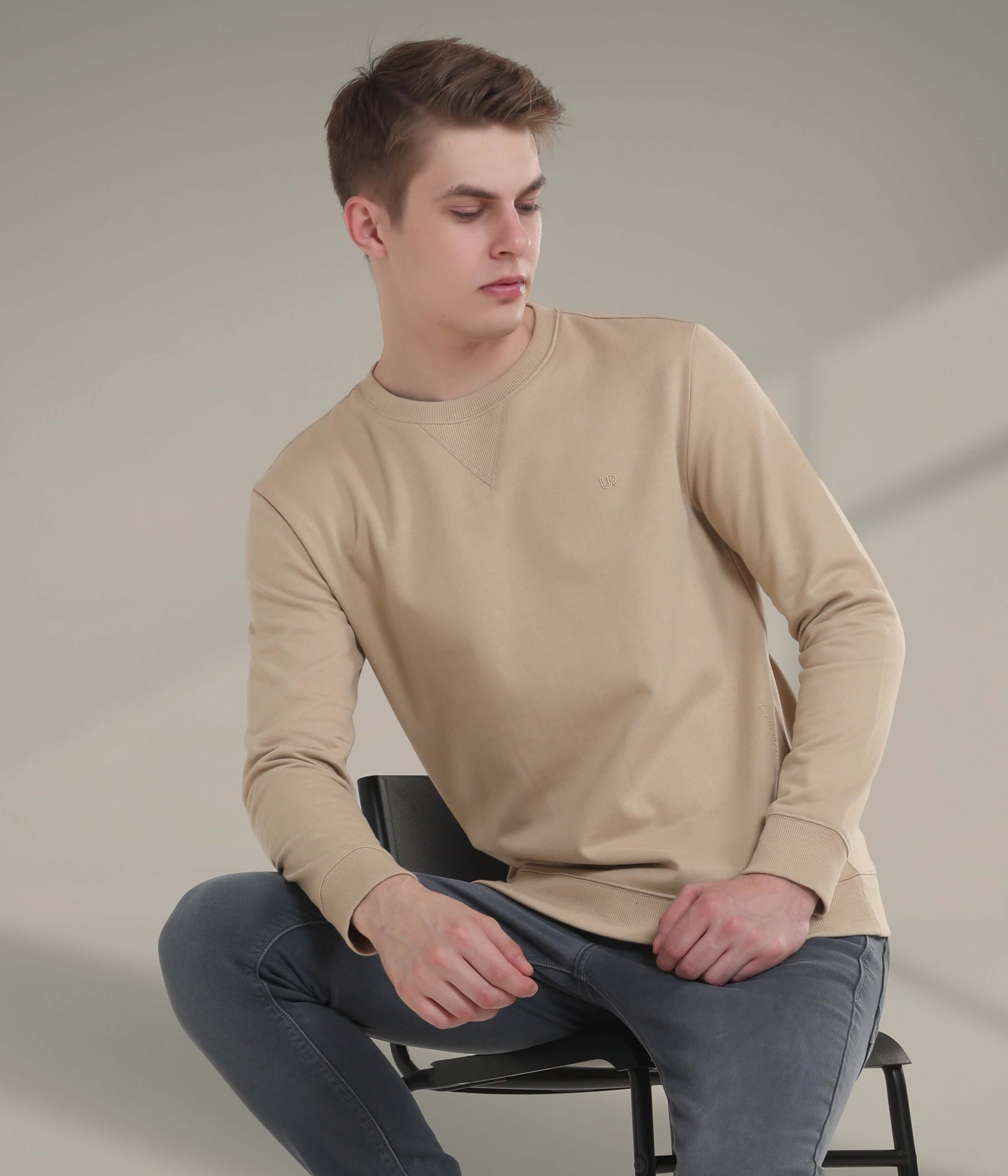 Stylish man wearing a beige Turms Intelligent Sweatshirt, showcasing comfort and premium cotton-blend fabric.