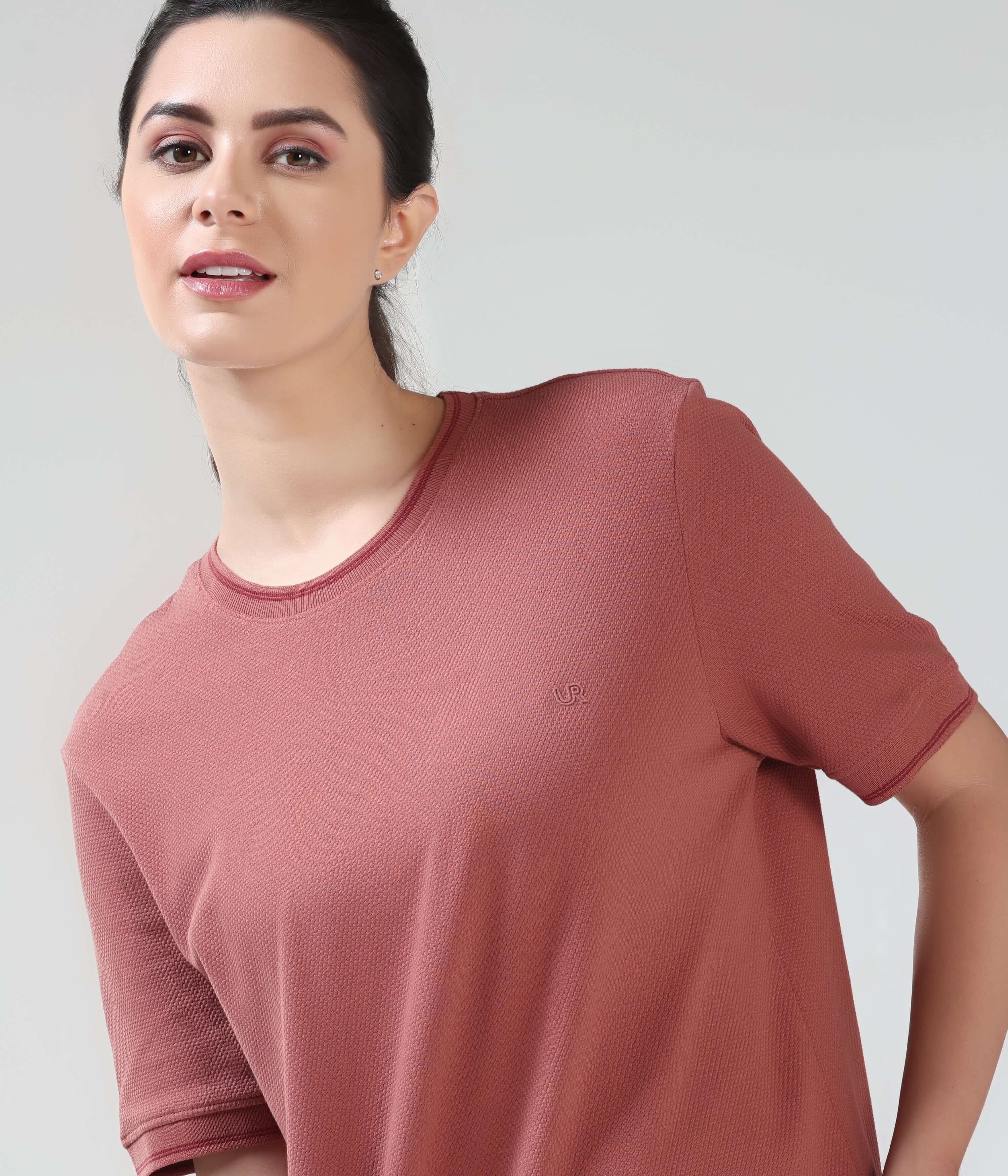 Woman wearing Vivid Brick CoolTech T-shirt from Turms, featuring anti-odour Honey Comb fabric and tailored fit for ultimate comfort.