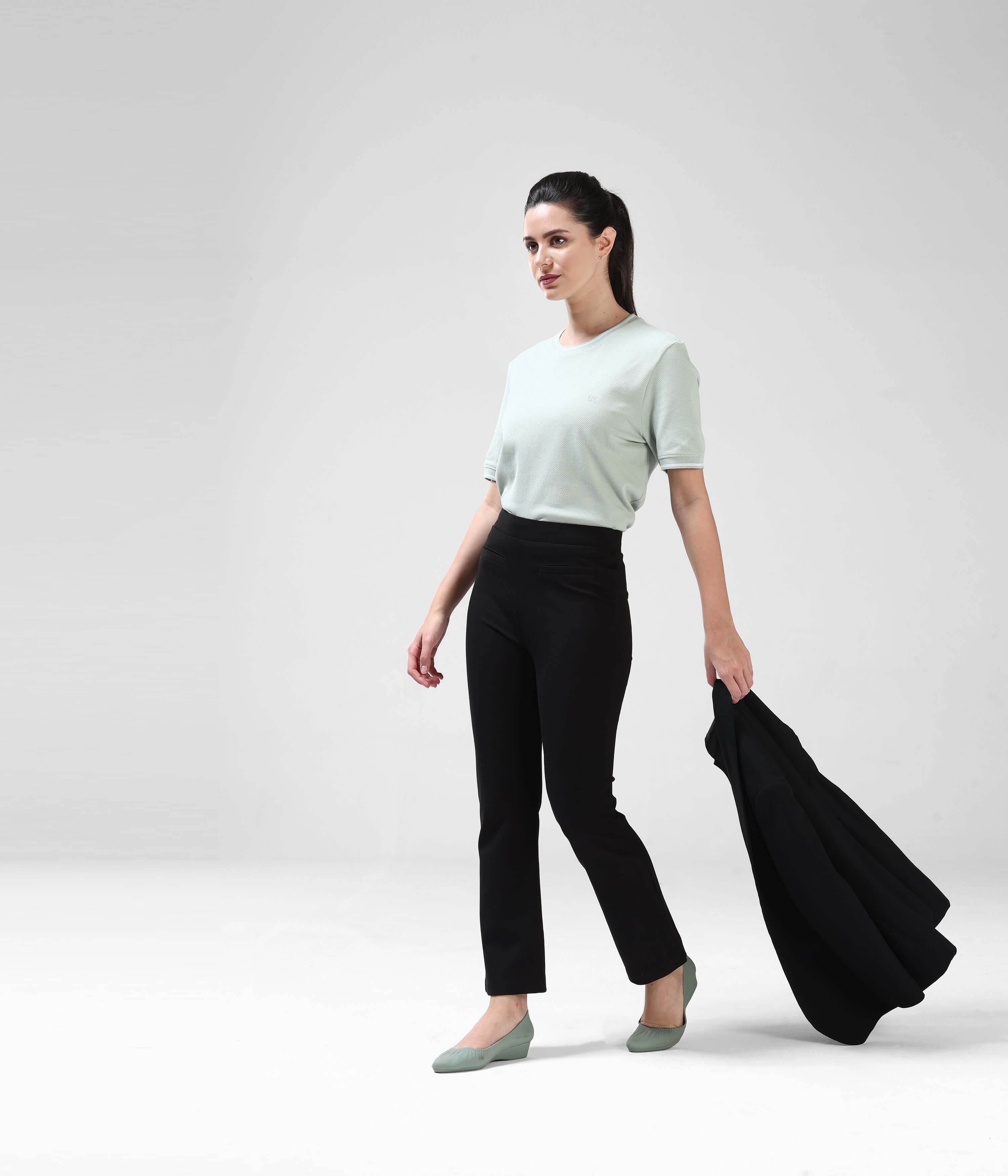 Woman wearing Serene Light Green COOLTECH T-shirt with honeycomb fabric and black pants. Anti-odour, anti-microbial Turms Intelligent Apparel.