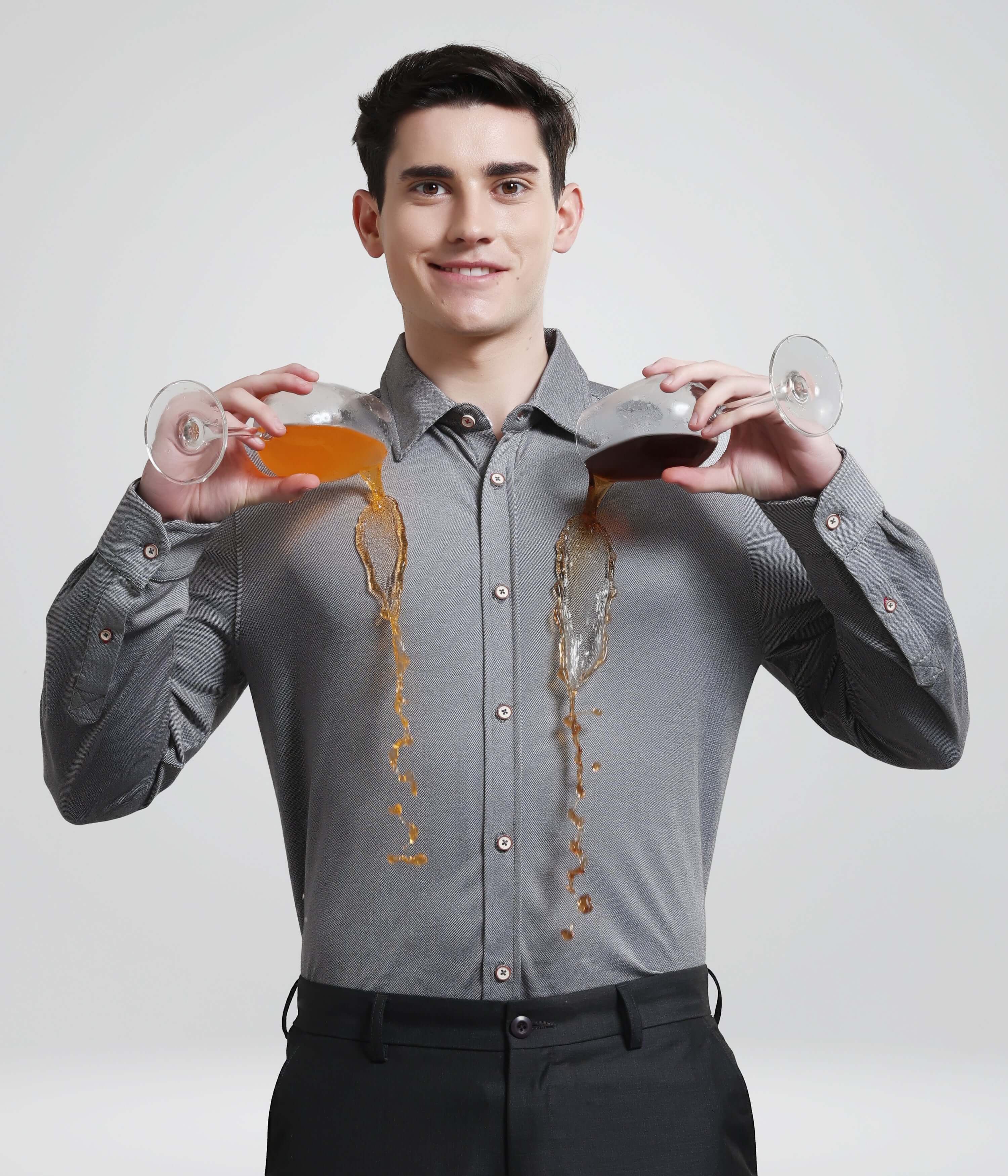 Man wearing Stormy Charcoal Knitted Turms Stretchable Shirt demonstrating anti-stain feature with liquid spill.