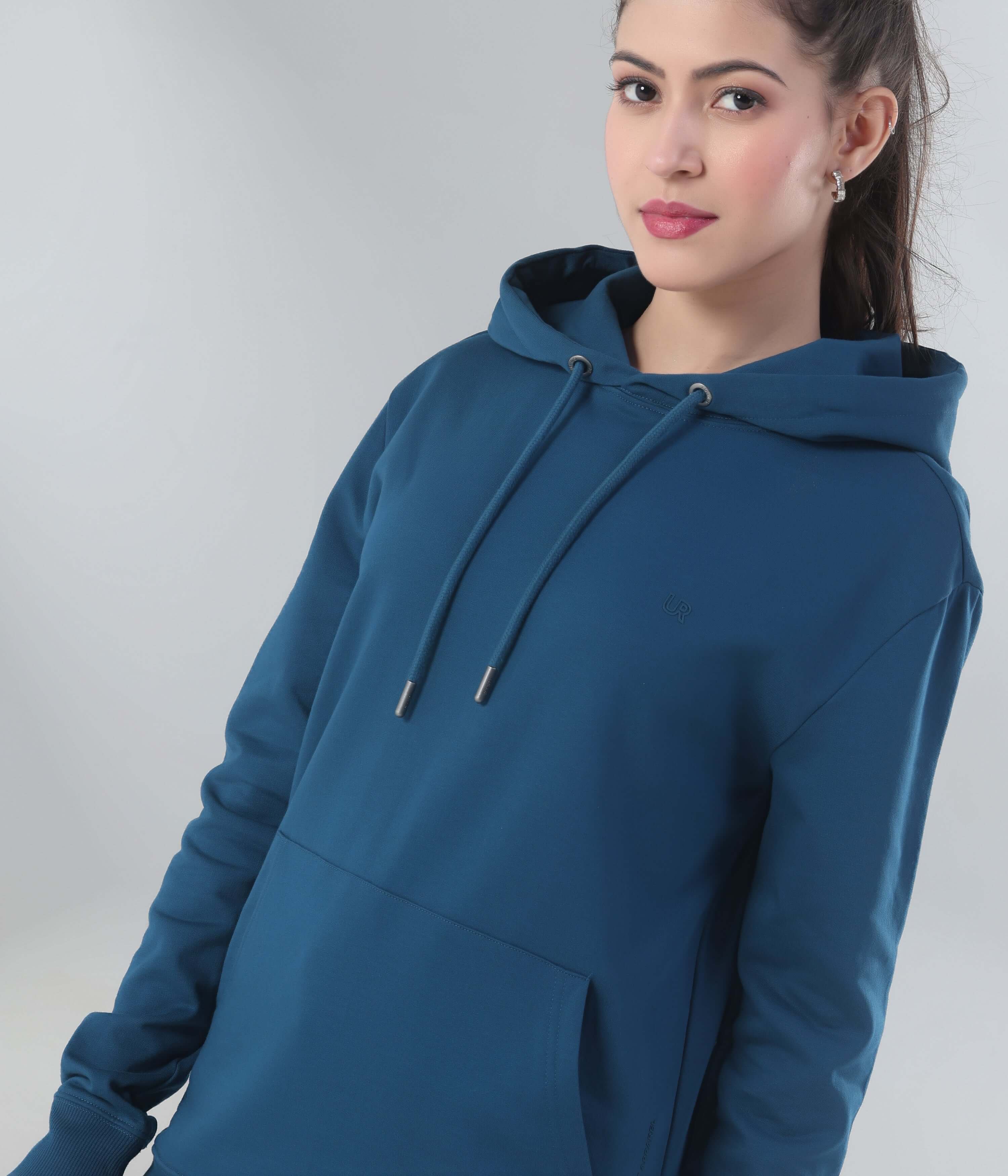 Stylish woman in a blue hoodie from Turms Intelligent Apparel, showcasing comfort and sporty design.