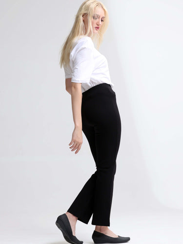 Woman wearing stylish white round-neck T-shirt and black pants, showcasing trendy casual wear for women.