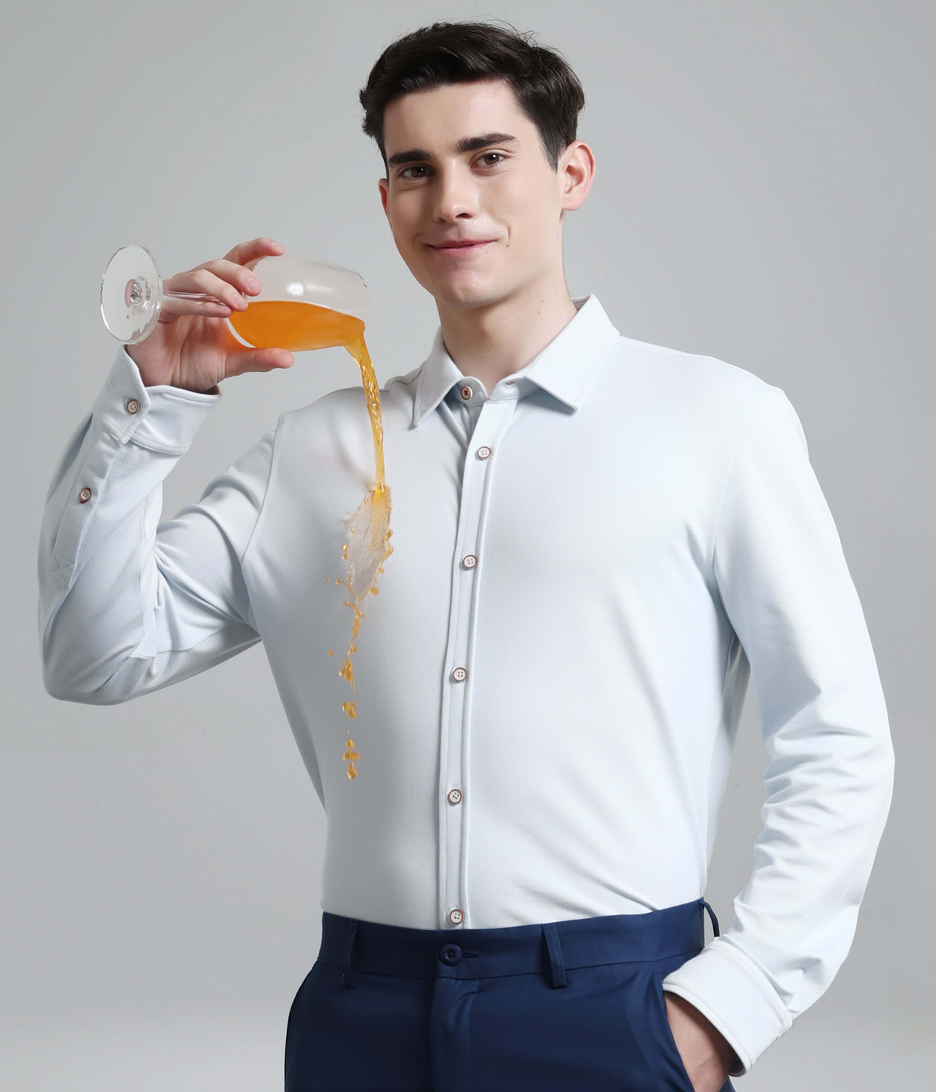 Man wearing Ethereal Blue anti-stain, anti-odour knitted shirt with drink spill, showcasing premium menswear durability.