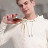 Man in cream waterproof hoodie pouring drink, showcasing stain-proof and stylish design for everyday wear.