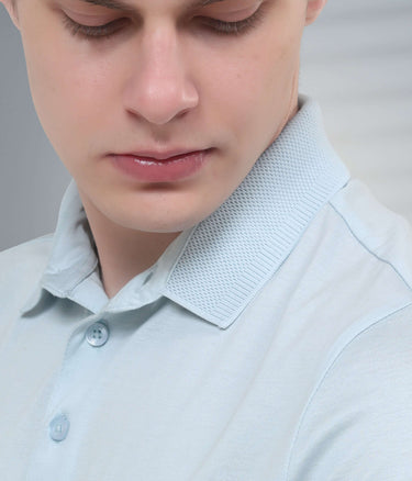 Close-up of a man wearing a light blue mercerized polo t-shirt with a textured collar, showcasing its stylish design.