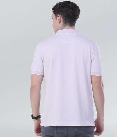 Back view of a man wearing a light pink zipped polo shirt, showcasing its sleek and modern design.