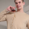 Model in beige sweatshirt demonstrating water resistance by spilling liquid without stains. Perfect for anti-odour menswear.