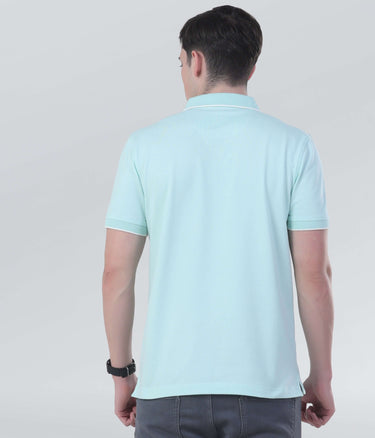 Back view of a man wearing a light blue polo shirt, showcasing sustainable style with anti-odour and water-repellent features.