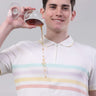 Man wearing a striped vanilla cream polo shirt, pouring liquid from a glass with a zipper detail.