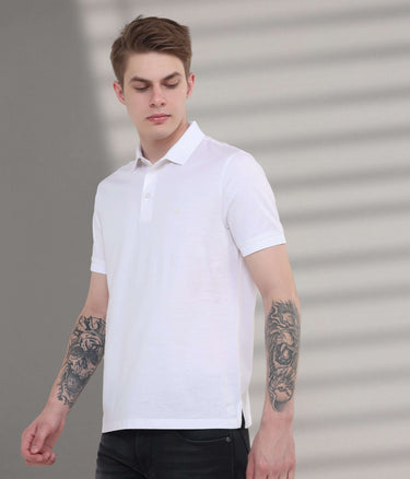 Stylish man wearing a white stain-proof polo t-shirt, showcasing tailored fit and premium cotton for everyday comfort.