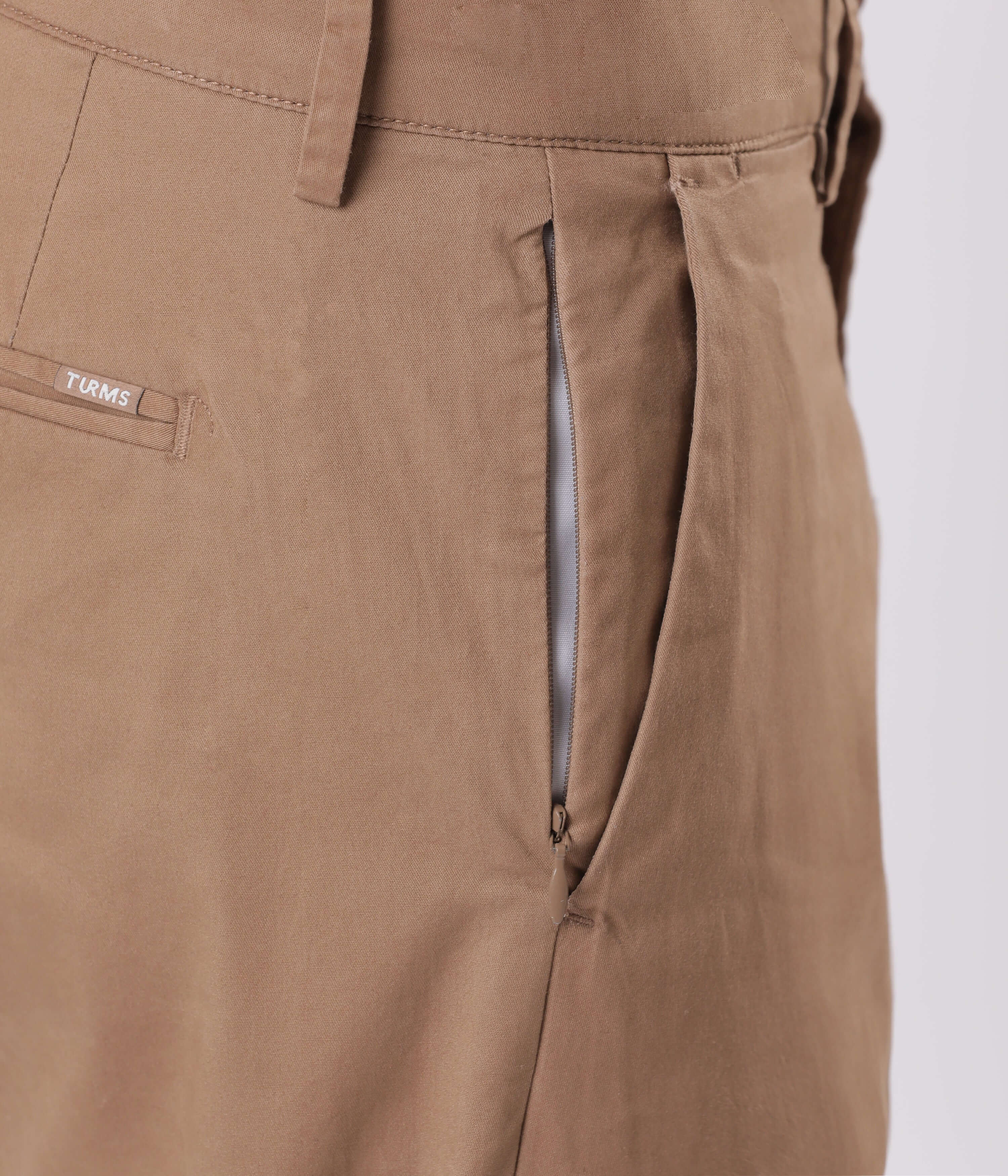 Close-up of Turms smart flex Chino detailing, showcasing the zipper and fabric of Dessert Mirage.