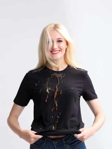 Woman wearing black stain-proof round-neck t-shirt demonstrating spill resistance. Stylish and trending shirts for men available.