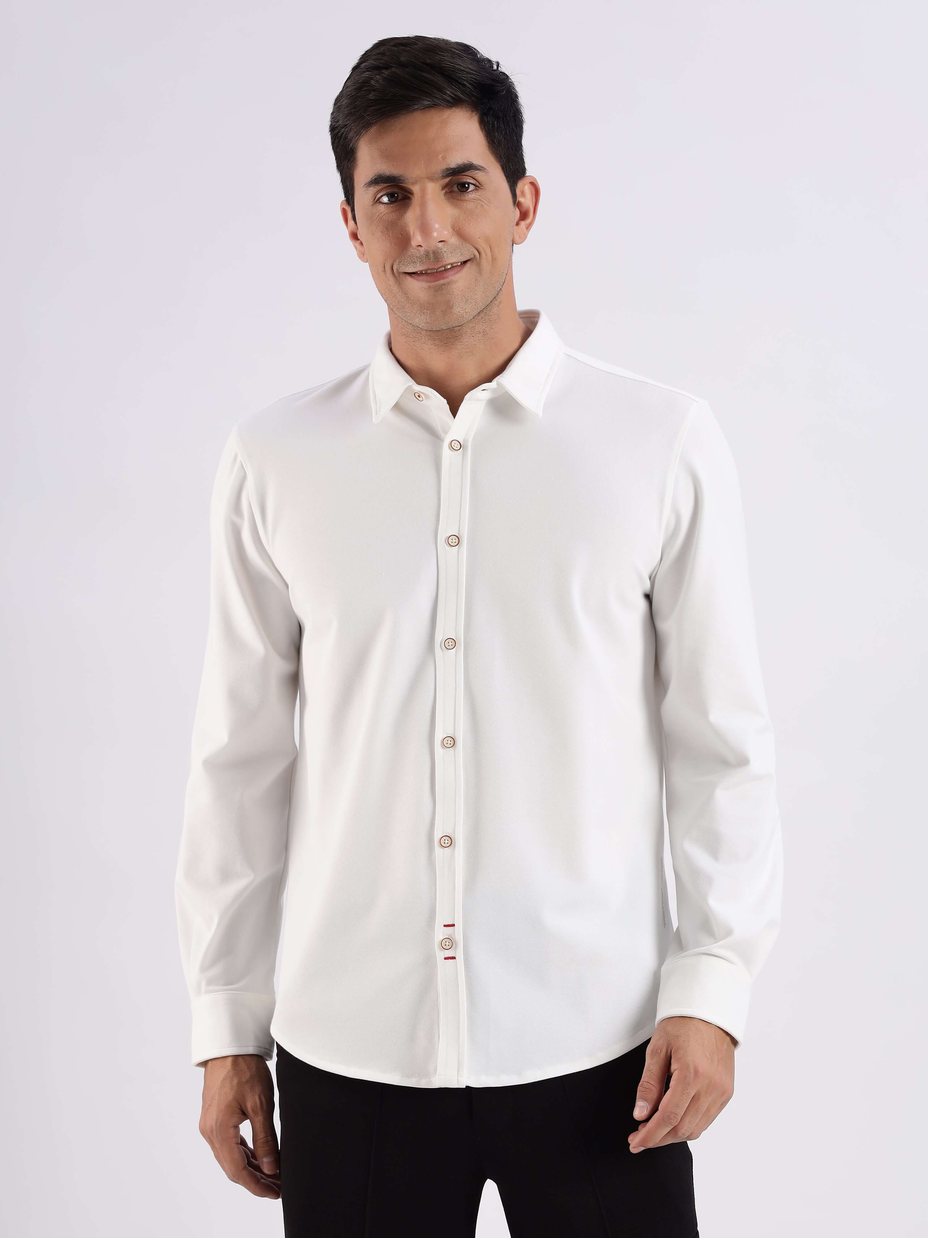 Stylish man wearing a white knitted shirt with 8-way stretch, anti-odour, and anti-stain features from Turms.