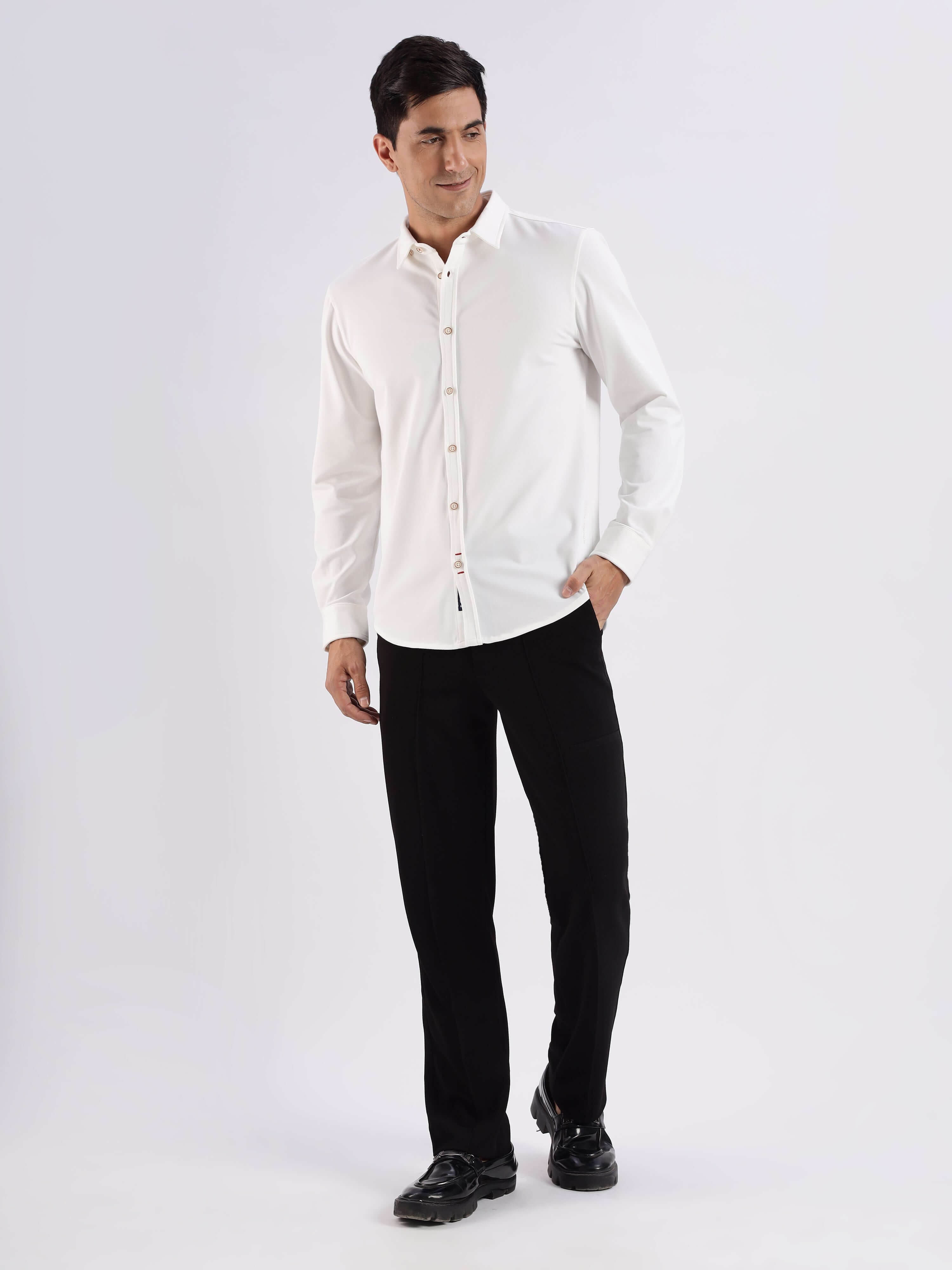 Man wearing a white knitted shirt with 8-way stretch and anti-odour features, paired with black trousers.