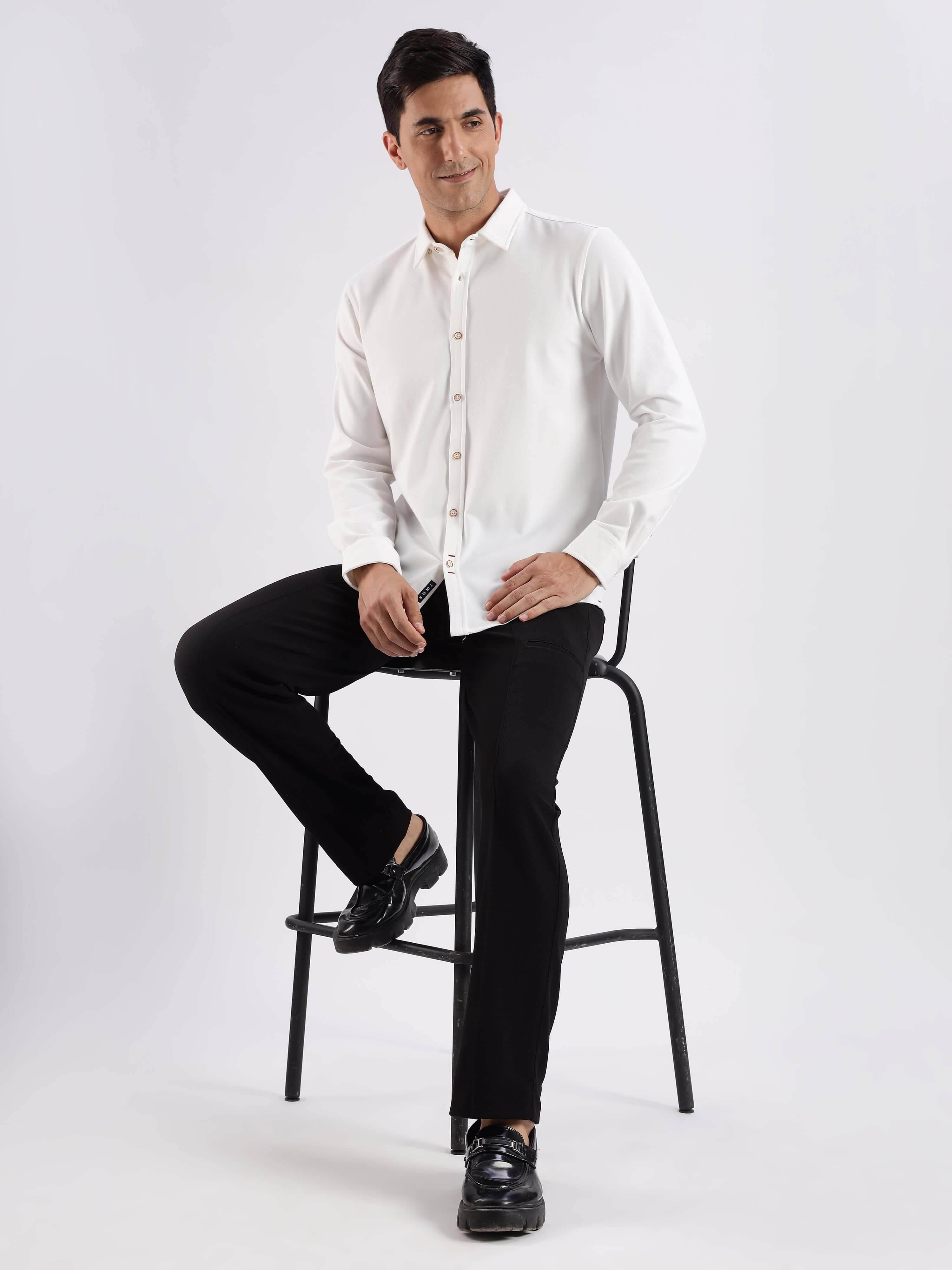 Stylish man wearing a white knitted shirt with 8-way stretch, anti-odour, and temperature control features.