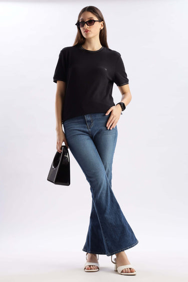 Model wearing Mandalorian Black cooltech t-shirt with flared jeans, showcasing style and comfort.