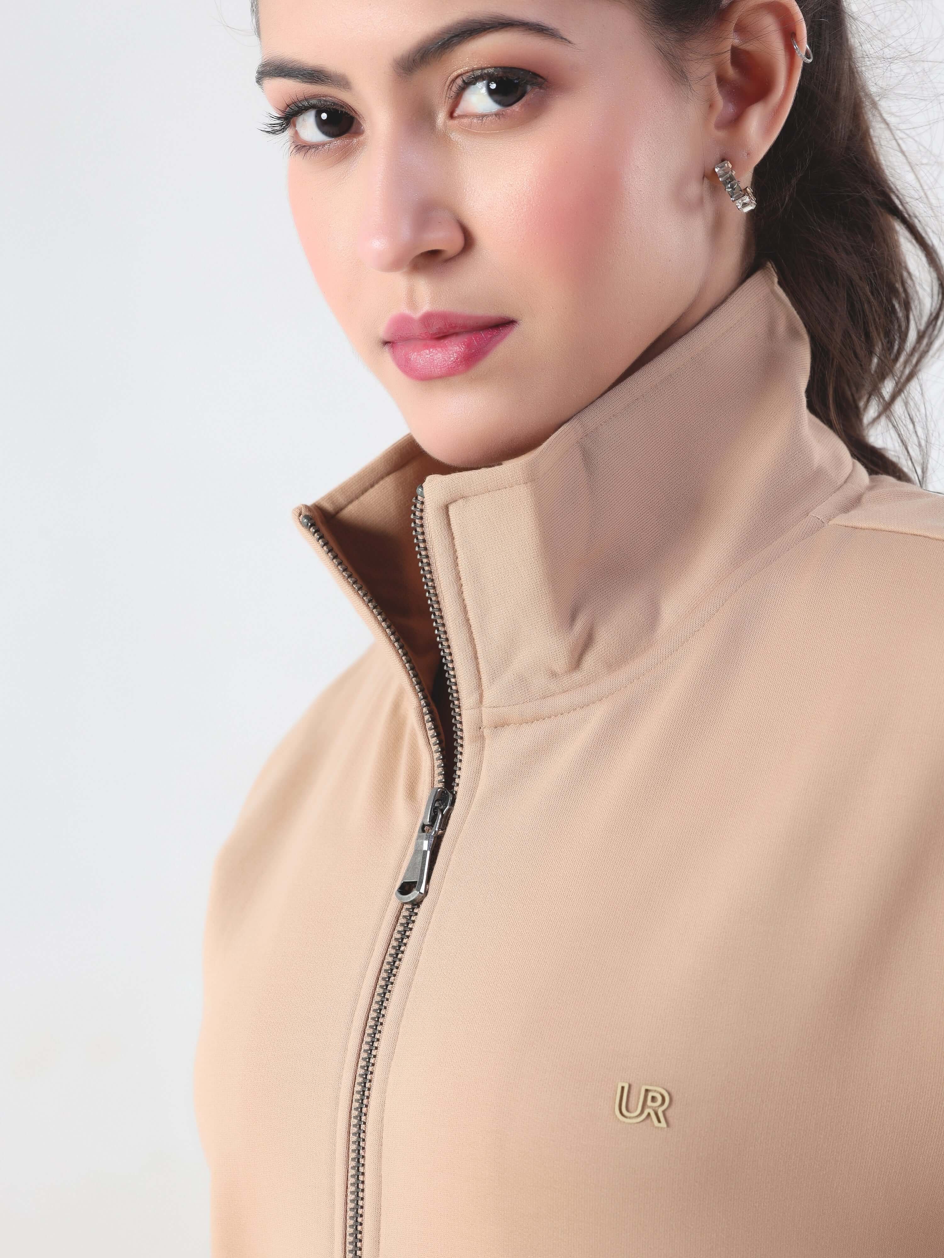 Close-up of a woman wearing a beige jacket with a high collar and zipper, showcasing comfort and style.