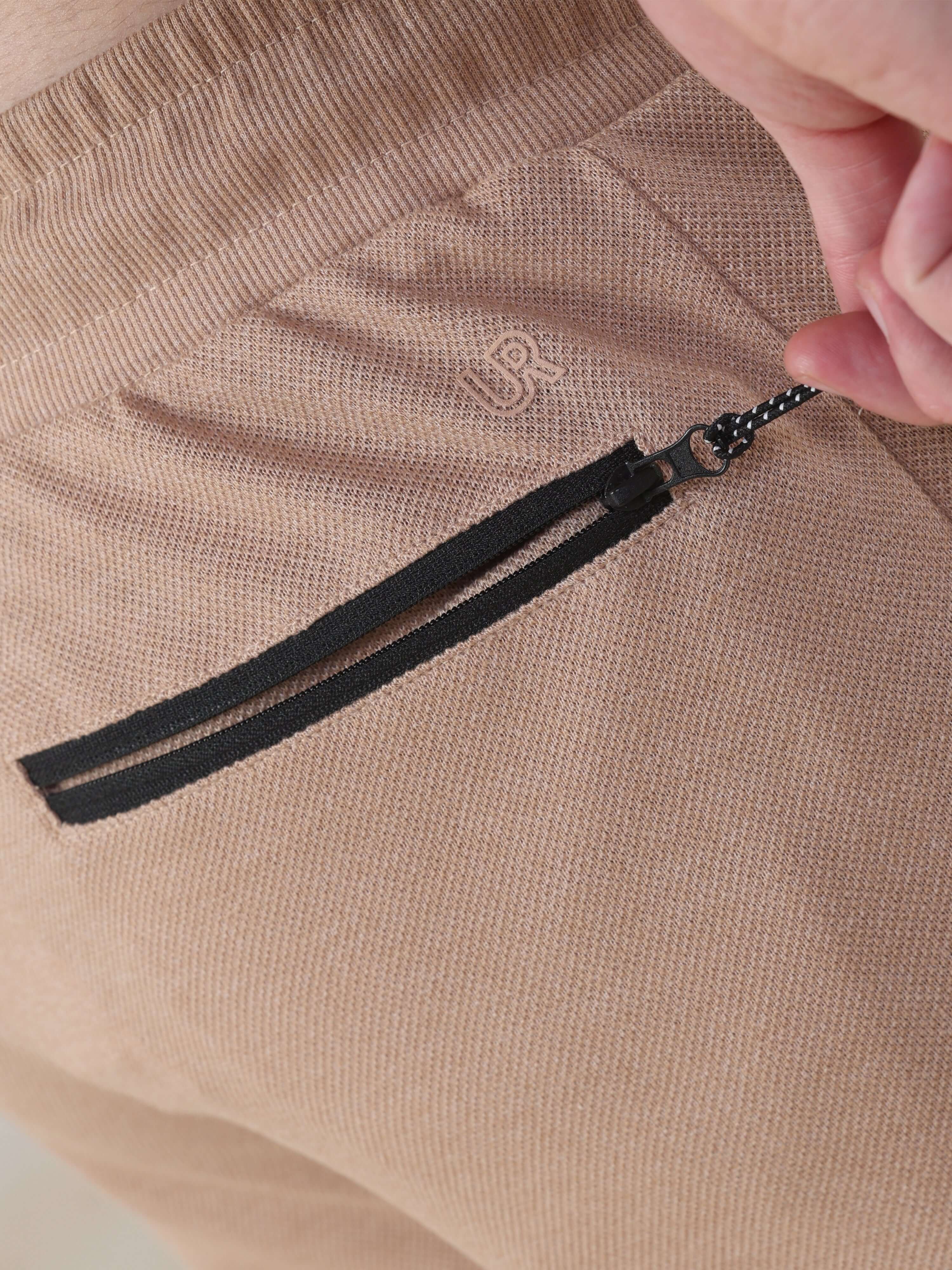 Close-up of Sahara Beige Turms Intelligent Jogger's zip pocket, showcasing style and functionality for men's travelers.