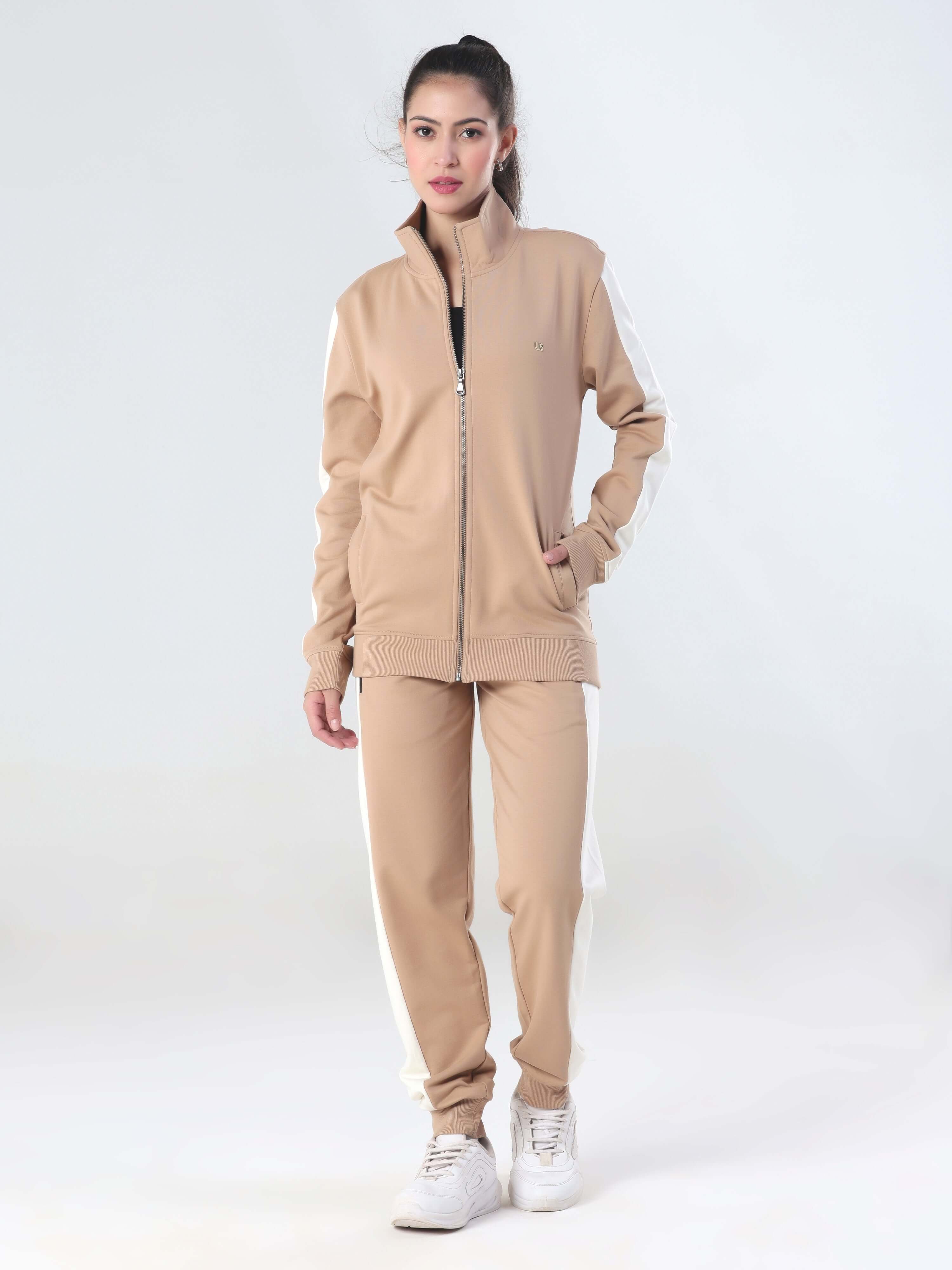 Woman wearing a sandy beige jogger and jacket coord set by Turms, featuring a modern sporty design.