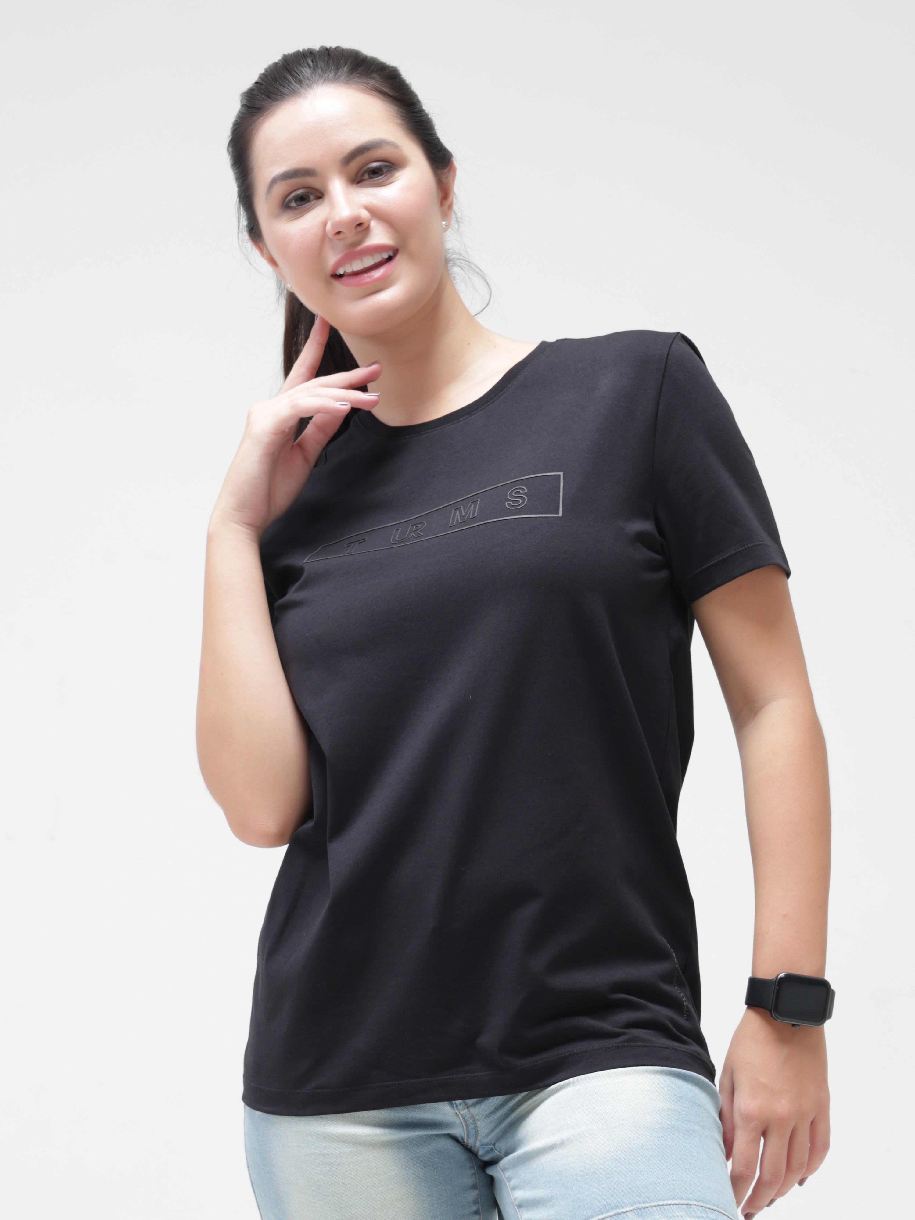 Woman wearing black round-neck Turms T-shirt, showcasing anti-stain, anti-odor, stretchable fabric. Intelligent apparel for a tailored fit.