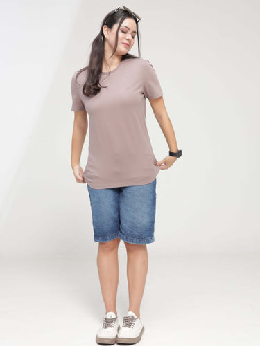 Woman wearing Dusky Maroon Turms T-shirt, anti-stain, anti-odor, stretchable, tailored fit, and intelligent apparel, paired with denim shorts.