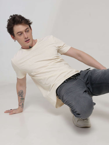 Man wearing Soft Peach Turms T-shirt lounging on the floor, showcasing anti-stain, anti-odour, stretchable intelligent apparel.