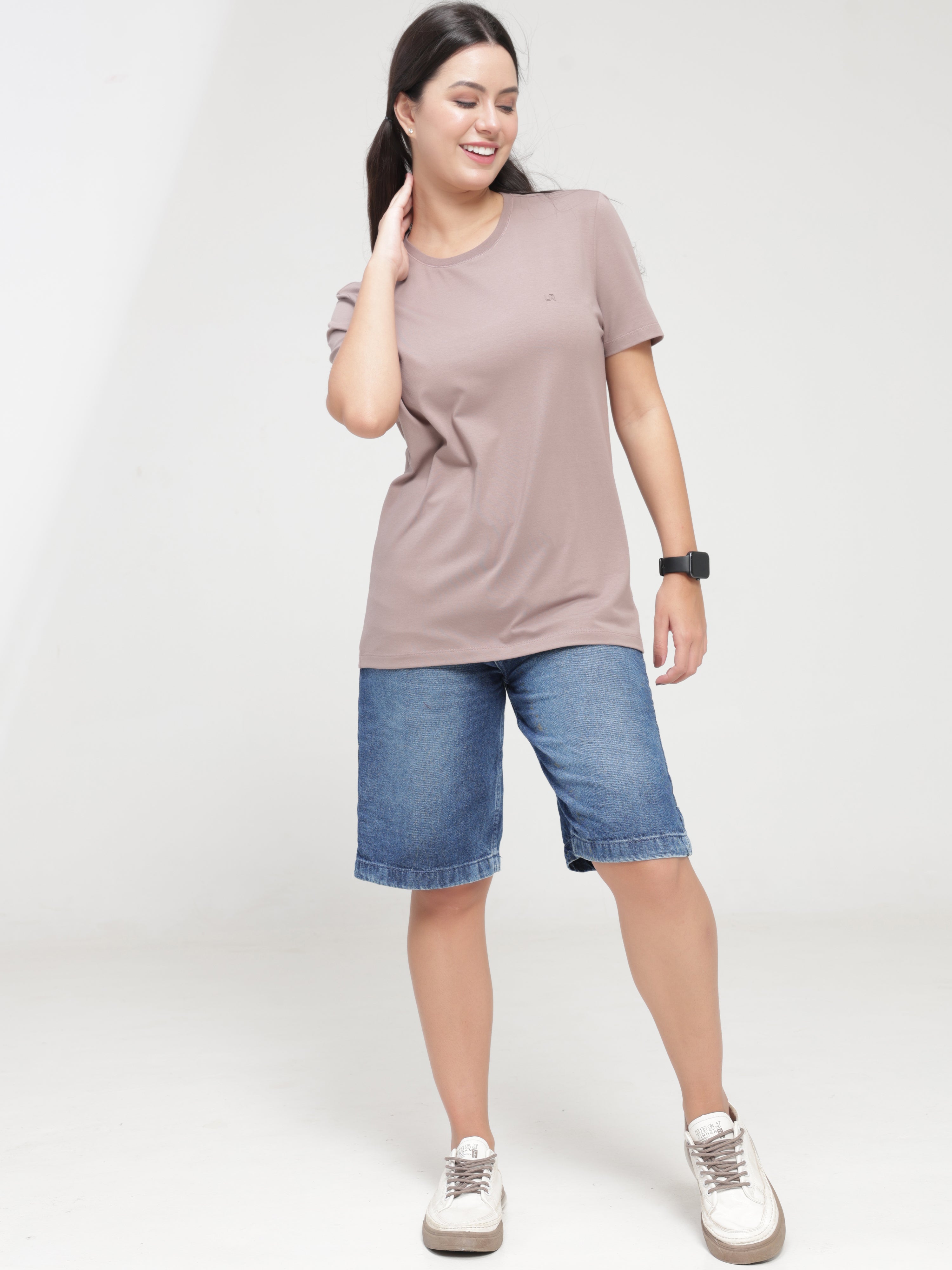 Woman wearing Dusky Maroon Turms anti-stain, anti-odour, and stretchable round-neck T-shirt with denim shorts.