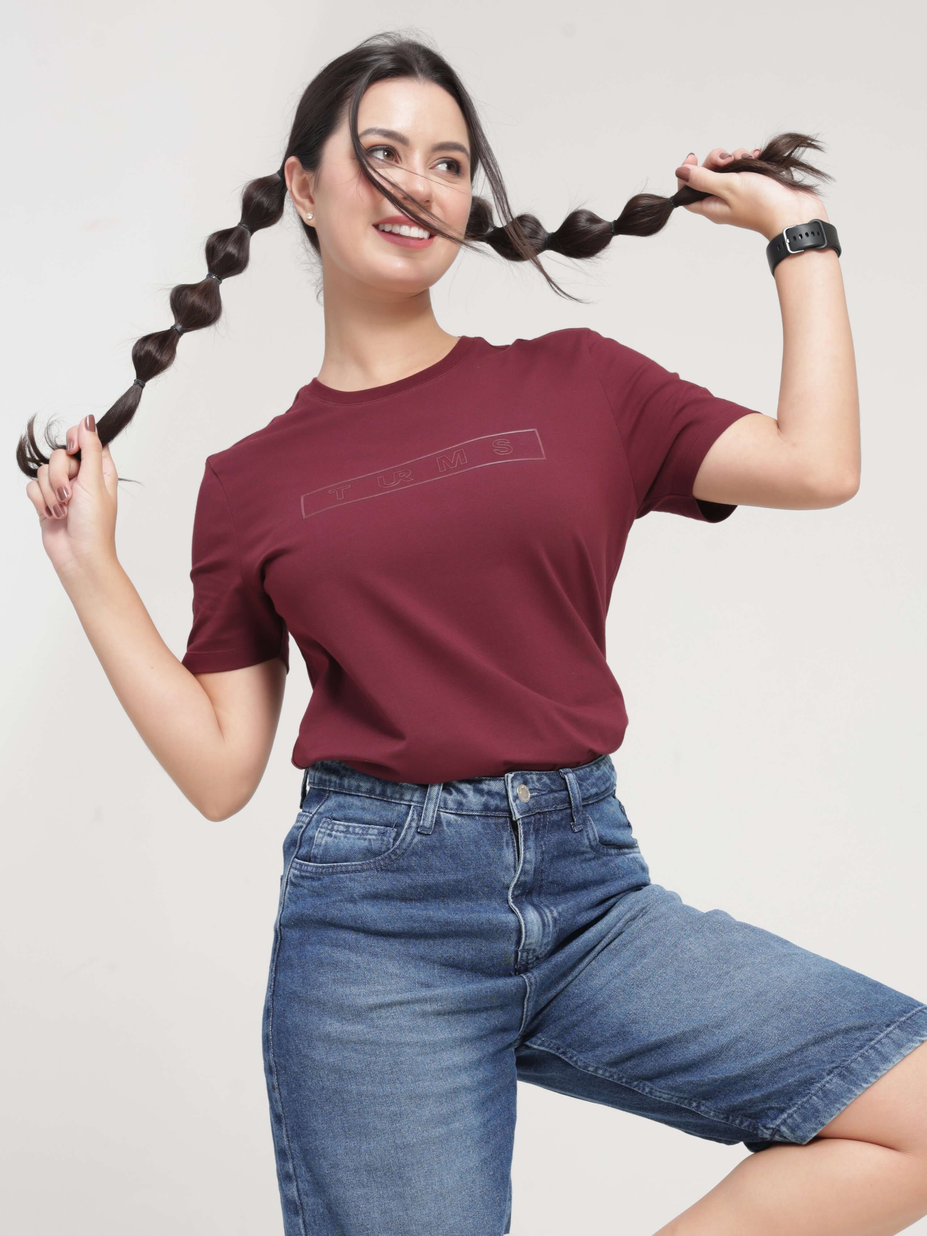 Woman wearing Burgundy Elite stain-proof, anti-odour Turms T-shirt with round neck and tailored fit, showcasing its stretchable fabric.