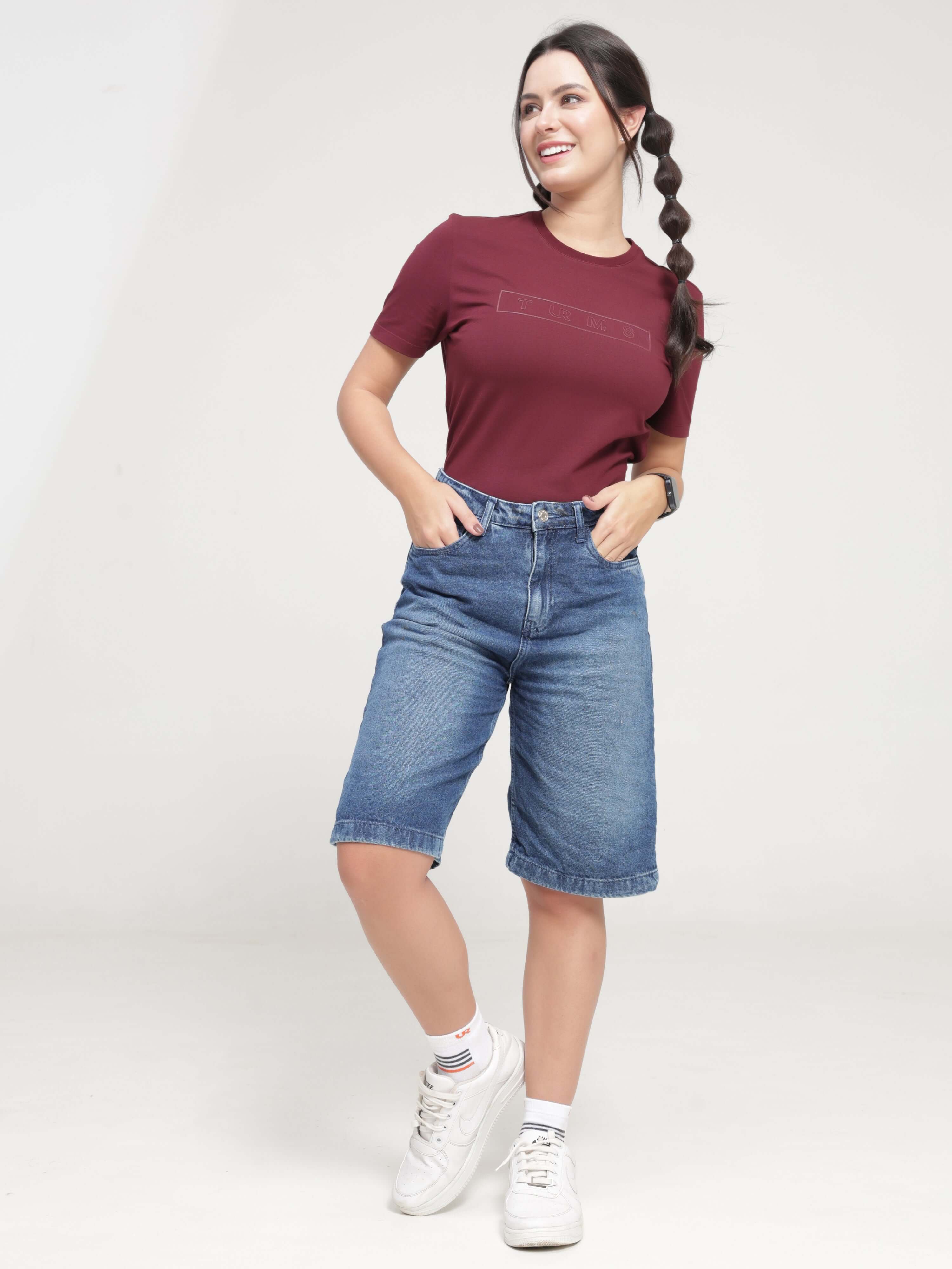 Woman wearing Burgundy Elite anti-stain, anti-odour, stretchable round-neck Turms T-shirt with denim shorts, best intelligent apparel for women.
