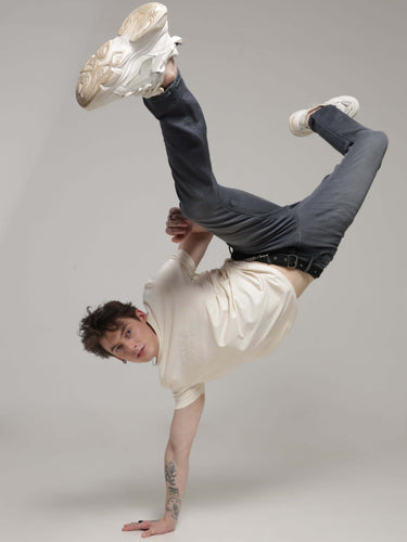 Man performing breakdance wearing soft peach Turms T-shirt with anti-stain, anti-odour, stretchable fabric.