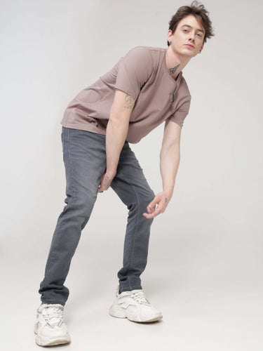 Man wearing Dusky Maroon round-neck Turms T-shirt, tailored fit, made of premium cotton and spandex, paired with jeans and white sneakers