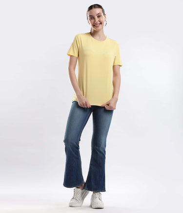 Woman wearing Womens casual t-shirt  Aura Yellow cotton t-shirt, showcasing its stretchable and water-proof features.