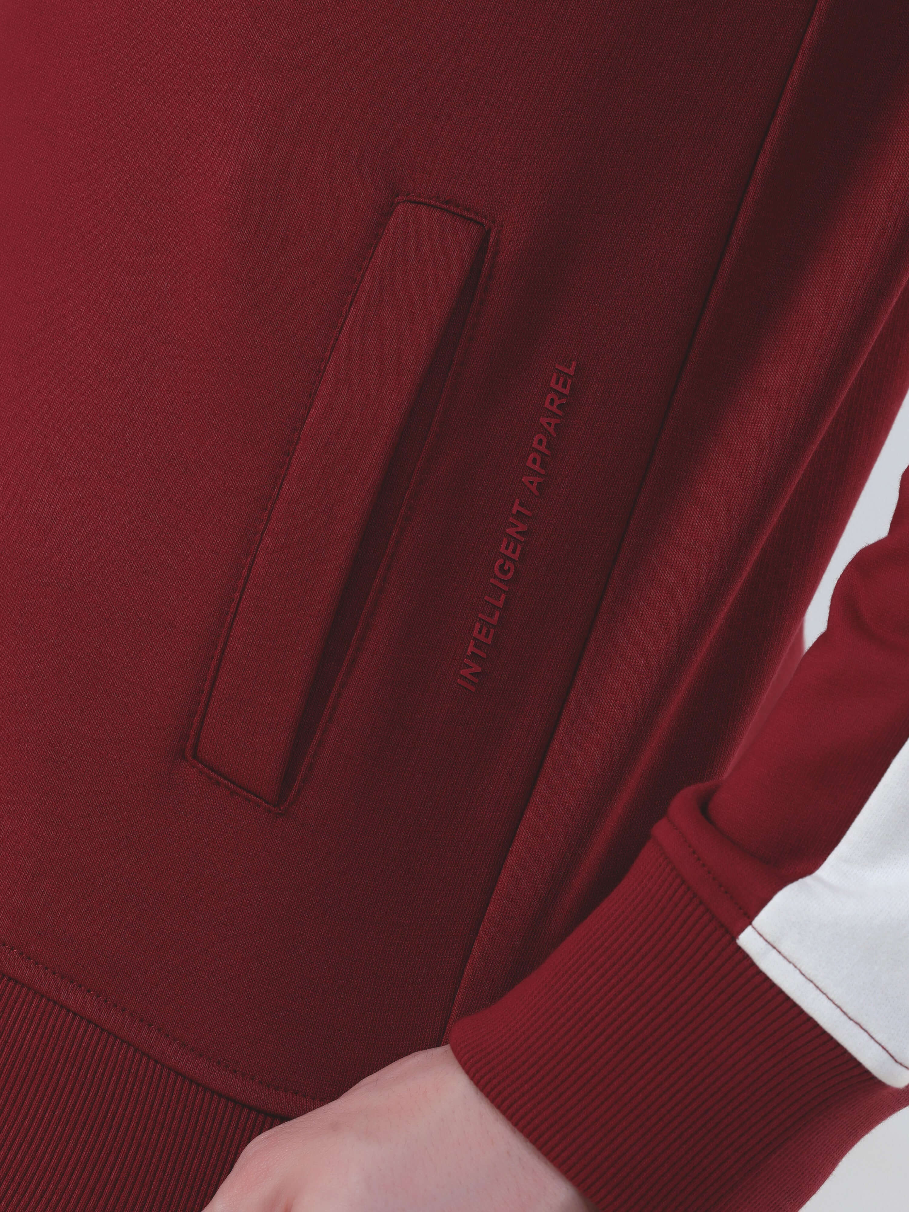 Close-up of the red Turms Intelligent Cord Set jacket showcasing a pocket and branding detail.