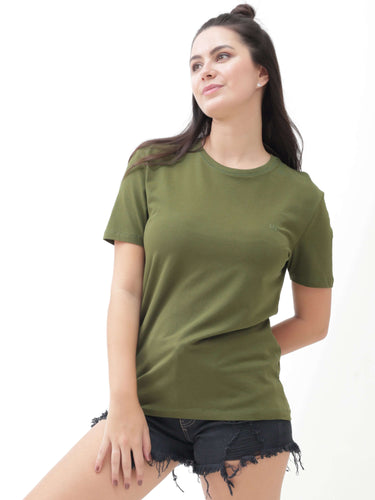 Woman wearing green round-neck Turms T-shirt, showcasing stain-proof and odor-resistant fabric, paired with black distressed shorts.