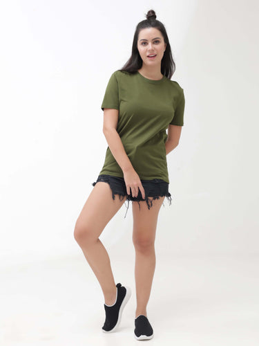 Woman wearing an olive green round-neck Turms T-shirt and black shorts, showcasing stylish and stain-proof apparel for women.