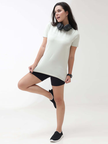 Woman wearing Lime Enigma Turms T-shirt, designed for anti stain, anti odour, and stretchable comfort, with headphones around her neck.