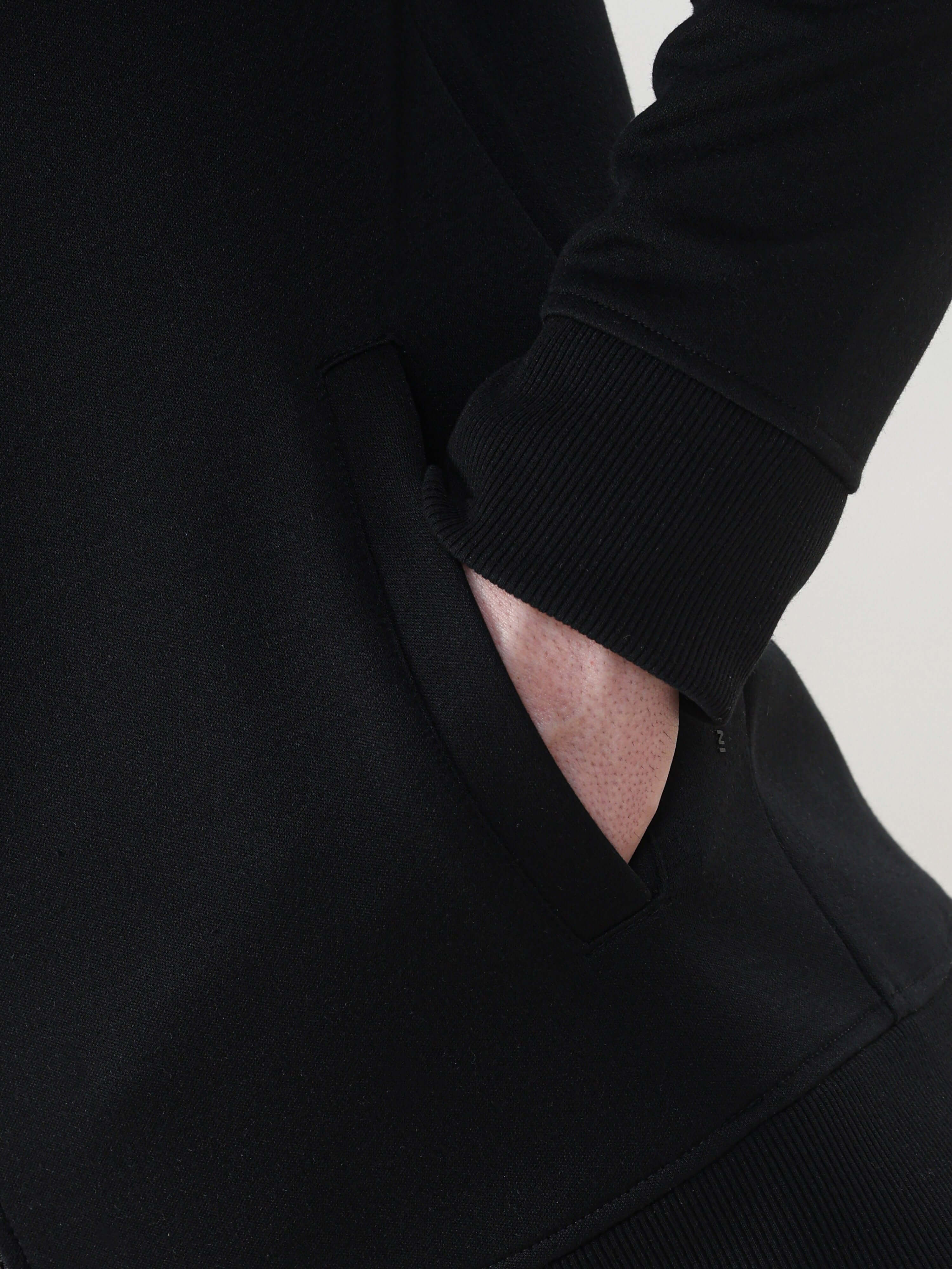 Close-up of a black jacket showcasing pocket detail and soft fabric, ideal for stylish, durable travel wear.